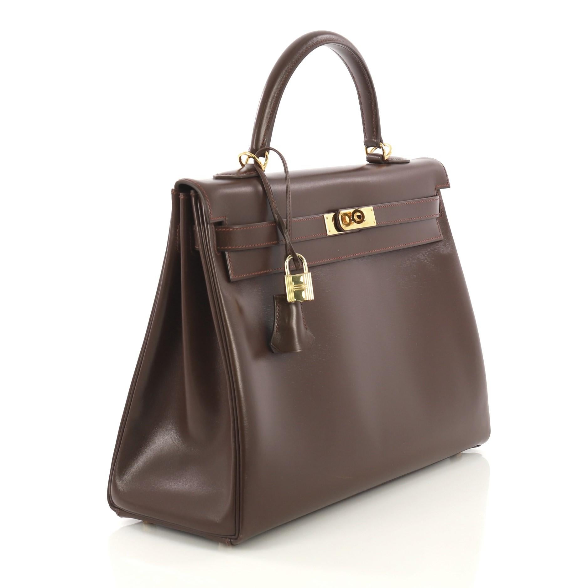 This Hermes Kelly Handbag Havane Box Calf with Gold Hardware 40, crafted from Havane brown Box Calf leather, features a single top handle strap and gold hardware. Its turn-lock closure opens to a Havane brown Chevre leather interior with zip and