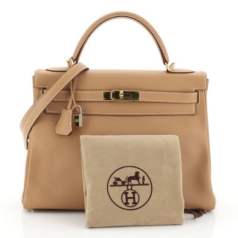 This Hermes Kelly Handbag Natural Courchevel with Gold Hardware 32, crafted from Natural brown Courchevel leather, features a single top handle and gold hardware. Its turn-lock closure opens to a Natural brown Chevre leather interior with zip and