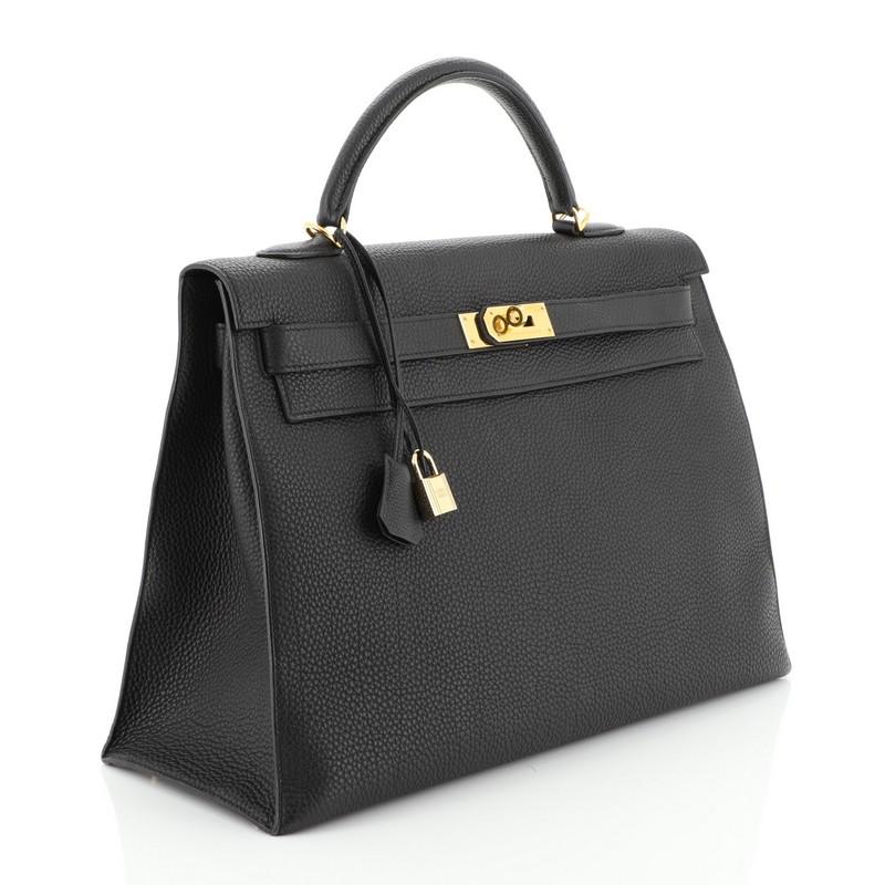 This Hermes Kelly Handbag Noir Togo with Gold Hardware 40, crafted in Noir black Togo leather, features a single rolled top handle, protective base studs, and gold hardware. Its turn-lock closure opens to a Noir black Chevre leather interior with