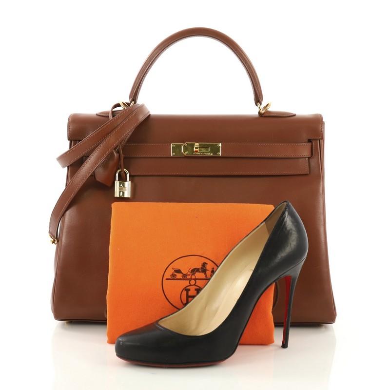 This Hermes Kelly Handbag Noisette Box Calf with Gold Hardware 35, crafted from Noisette brown Box Calf leather, features a single top handle strap, and Gold hardware. Its turn-lock closure opens to a Noisette brown Chevre leather interior with zip