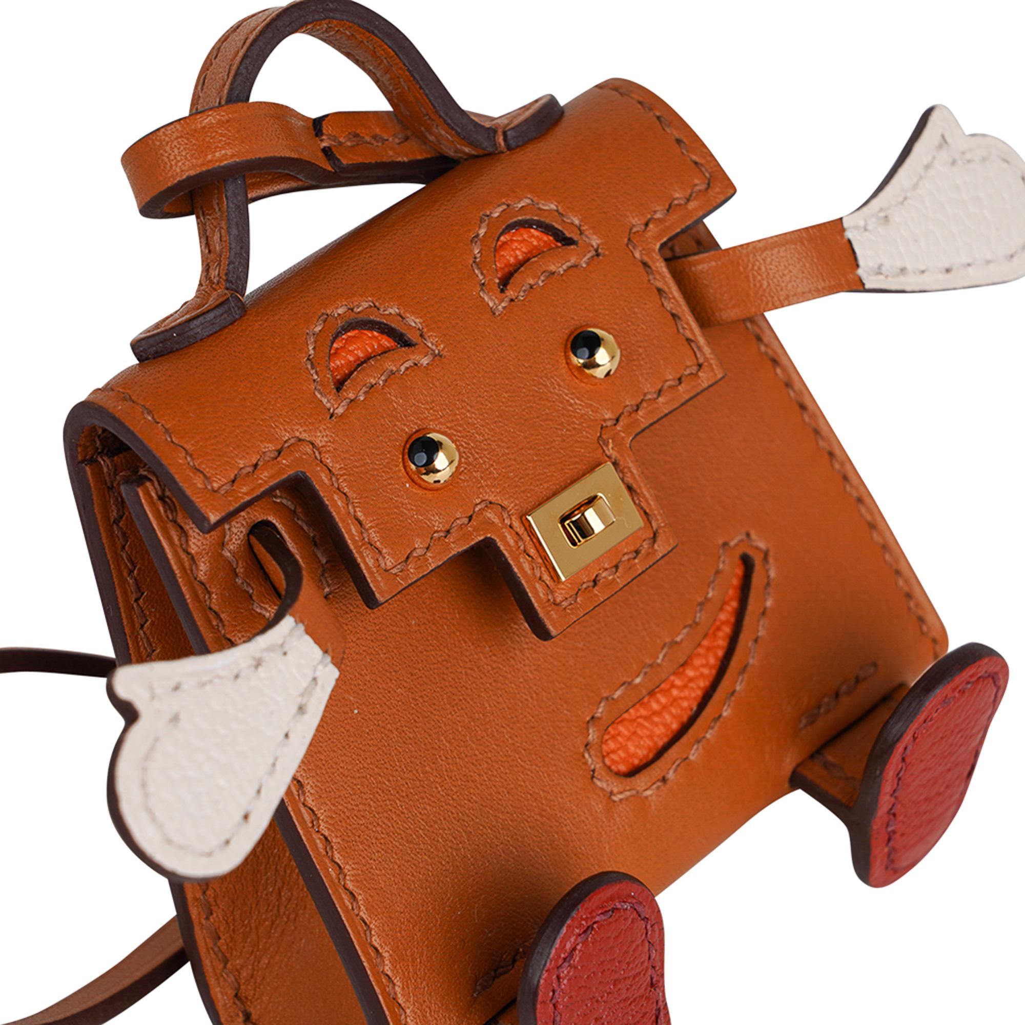 Mightychic offers a very rare limited edition Hermes Kelly Idole bag charm featured in Sable, Nata, H Orange and Brique Tadelakt leather.
Whimsical and delightful this fabulous charm has a turn lock that works.
Gold hardware accentuates the naughty