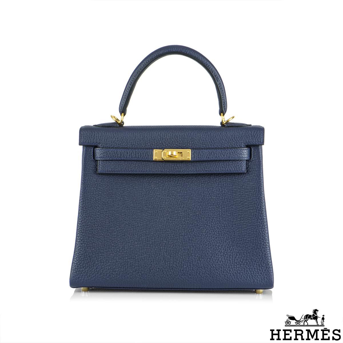 An exquisite Hermès Kelly II Retourne 25cm Blue Nuit Handbag. The rich navy blue colour is complemented with gold hardware. The exterior of this Kelly features a Retourne style in blue nuit togo leather. It has a front toggle closure, a single