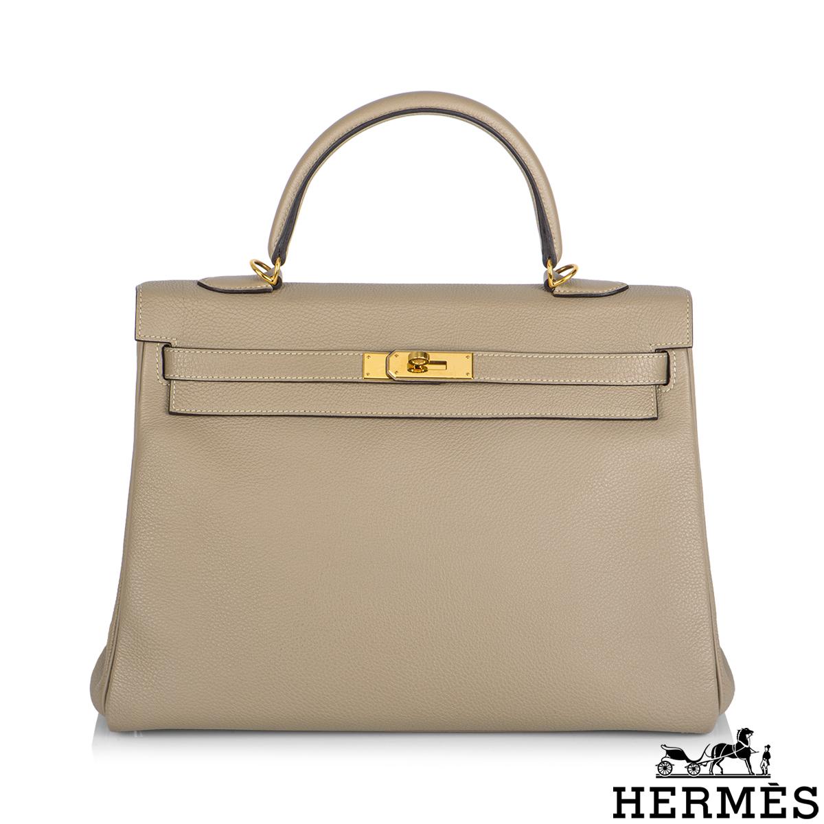 A beautiful Hermès Kelly II Retourne 35cm bag. The Gris Tourterelle Veau Togo leather bag is detailed with gold-tone hardware. The exterior of this Kelly features a front toggle closure, a single rolled top handle and tonal stitching. The interior