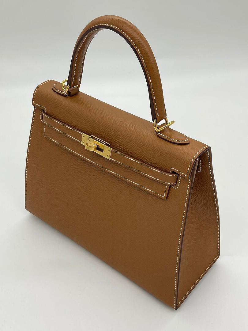- Dimensioni: 28 cm (L) x 22 cm (H) x 10 cm (P)
- Colore: Oro classico, una tonalità calda e versatile.
- Hardware: Accessori placcati in palladio, tra cui l'iconica chiusura Kelly, il lucchetto e le chiavi.
- Caratteristiche: Maniglia superiore e