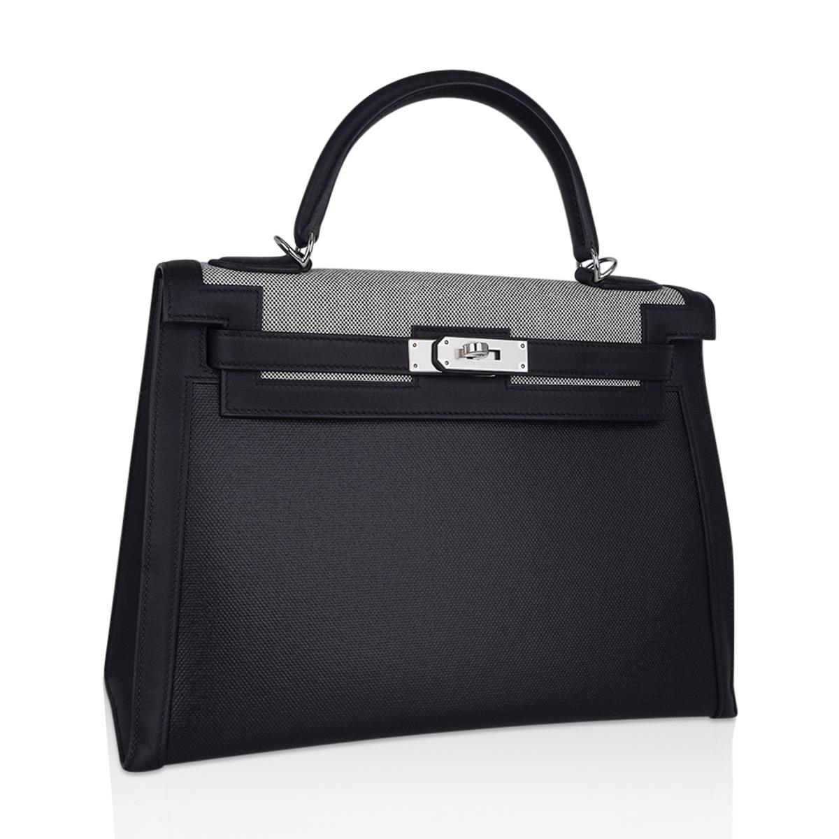 Mightychic offers a  Limited Edition Hermes Kelly II Sellier 32 bag.
This striking bag is featured in Toile H Berline, a coated canvas,  and Toile H Plume.
Finished in Black Swift leather..
This  beautiful Hermes Kelly bag is accentuated with crisp