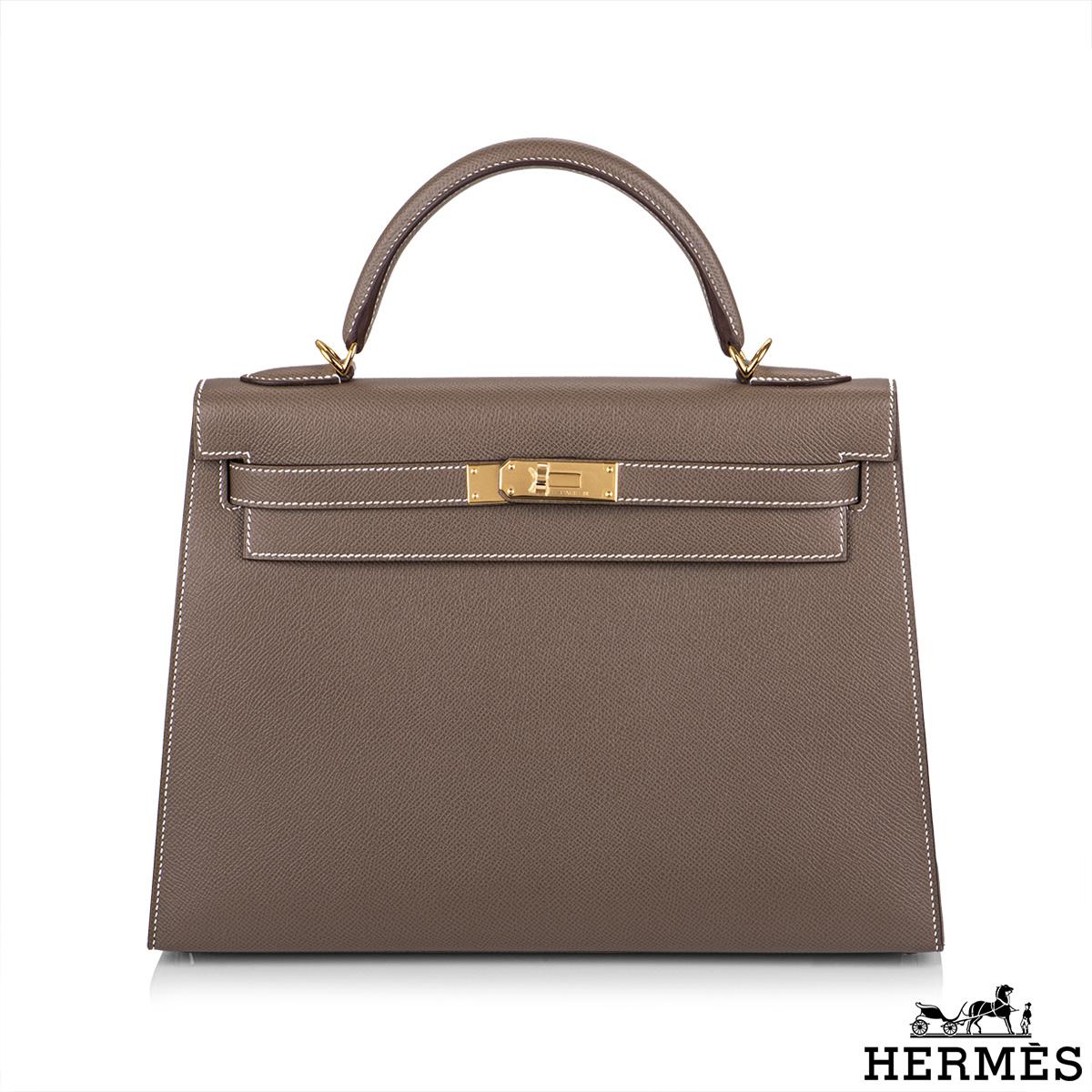 An exquisite Hermès Kelly II Sellier 32cm Epsom Etoupe handbag. The exterior of this Kelly features a sellier style in etoupe epsom leather. The etoupe epsom leather is complimented with gold hardware and contrast white stitchings. It features a