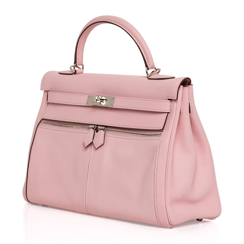 Garantie d'authenticité de l'édition limitée du sac Hermès Kelly Lakis 32 en Rose Sakura.
Poches avant et poches à glissière signées.
Cuir Swift avec matériel Palladium.  
Cette beauté est sûre de devenir votre sac ultime !
Livré avec sangle,