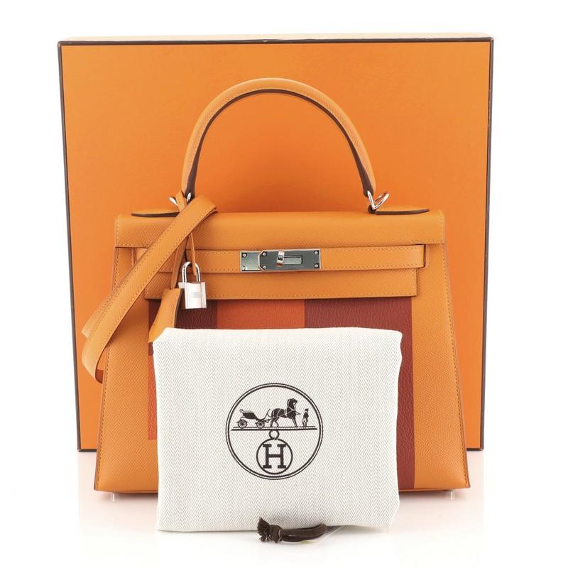 This Hermes Kelly Lettre Handbag Feu Epsom with Palladium Hardware 28, crafted in Abricot, Brique red, and Feu orange Epsom and Chevre Mysore leather, features a single rolled top handle, frontal flap, and palladium hardware. Its turn-lock closure