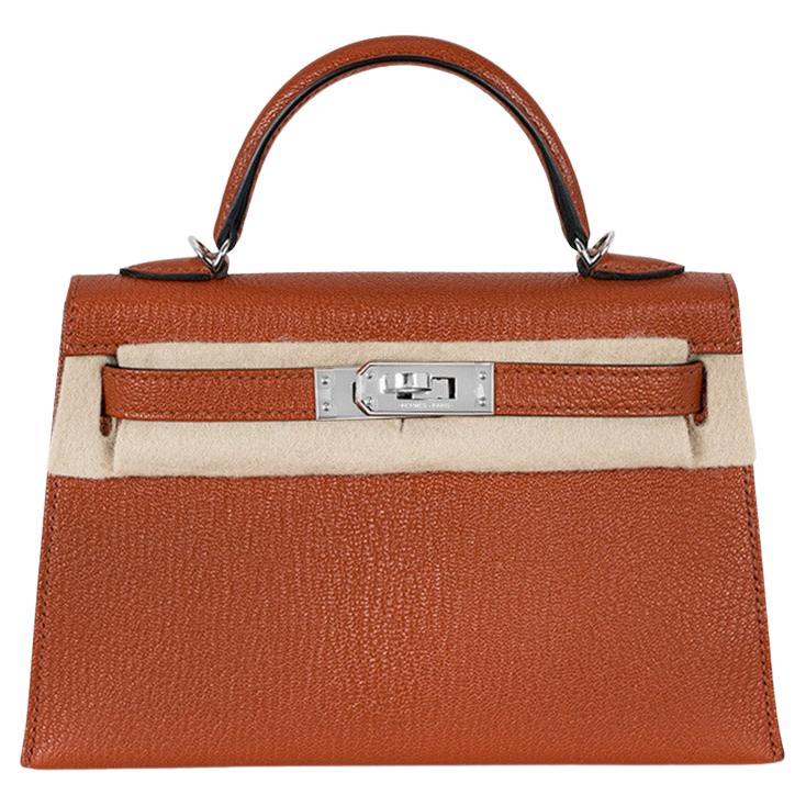 A beautiful Hermès Kelly Mini II handbag. The exterior of this Kelly Mini features Cuivre Chèvre Mysore leather and is complemented by palladium hardware and tonal stitchings. It has a front toggle closure with two straps, a single rolled handle and
