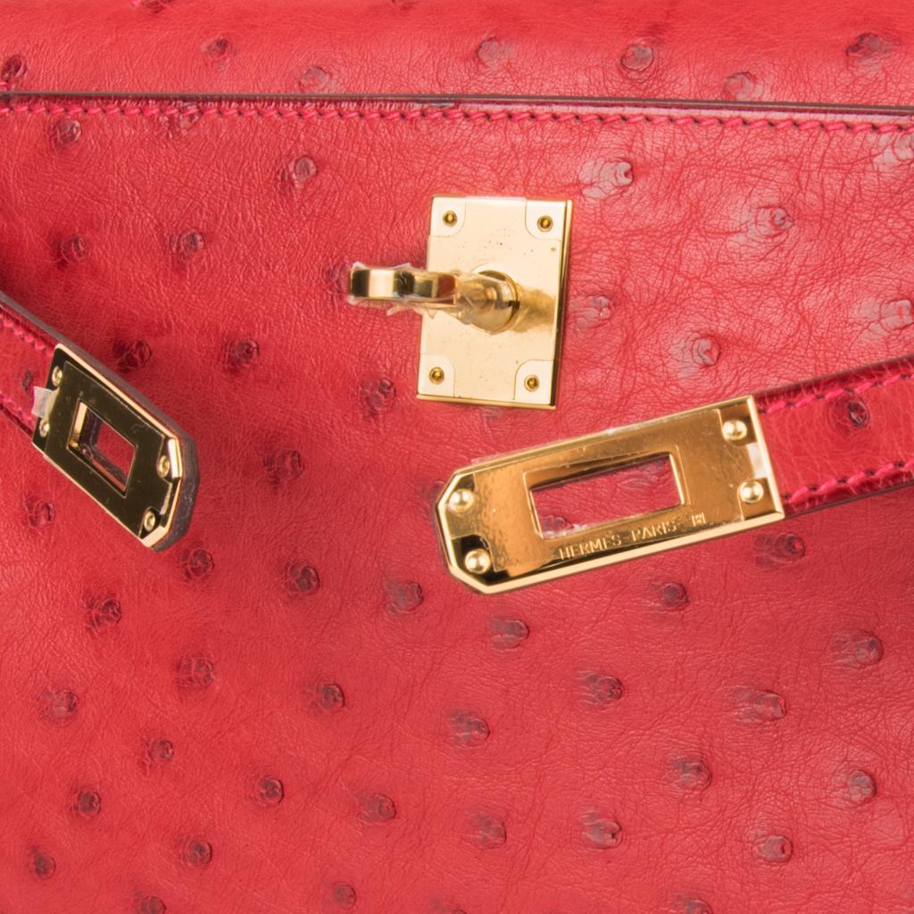 Guaranteed authentic Hermes Kelly pochette bag featured in rich Rouge Vif Ostrich.
This beautiful Hermes clutch is accentuated with gold hardware and the signature pink top stitch.
Signature stamp on interior.
Small interior compartment.
Comes with