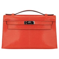 Pochette Kelly di Hermes in lucertola color mandarino con minuteria in rutenio