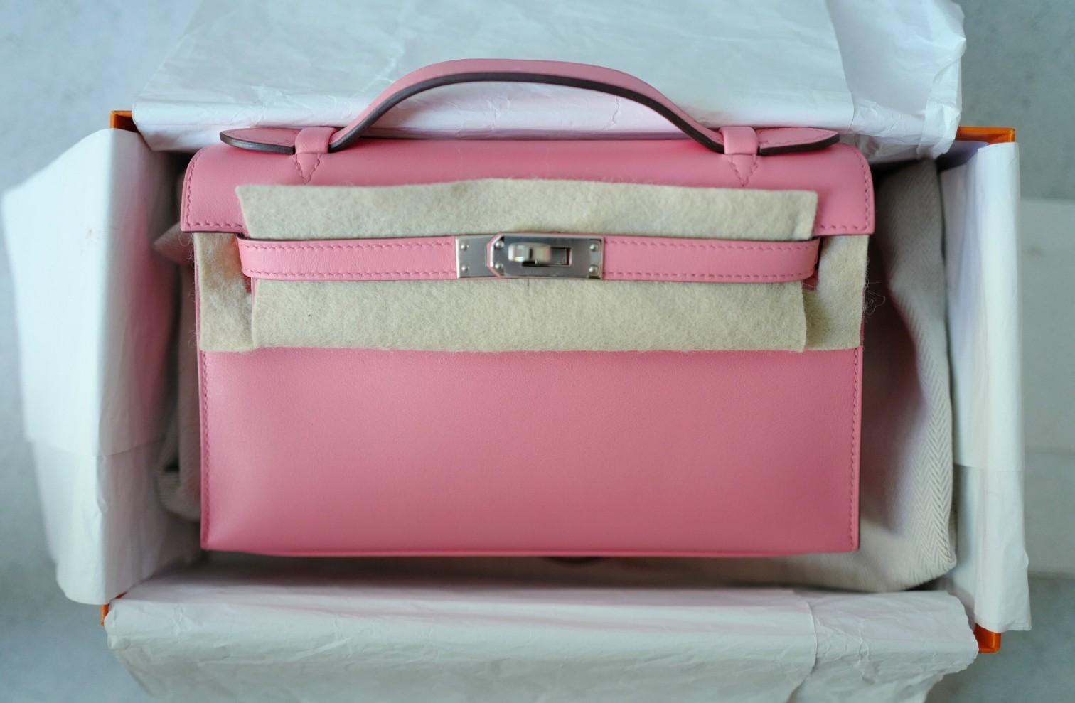La Pochette Herm�ès Kelly in Pelle Rose d'Été Swift con Hardware Palladium è un'espressione radiosa di eleganza femminile. La sua morbida tonalità rosa, giustamente chiamata Rose d'Été (
