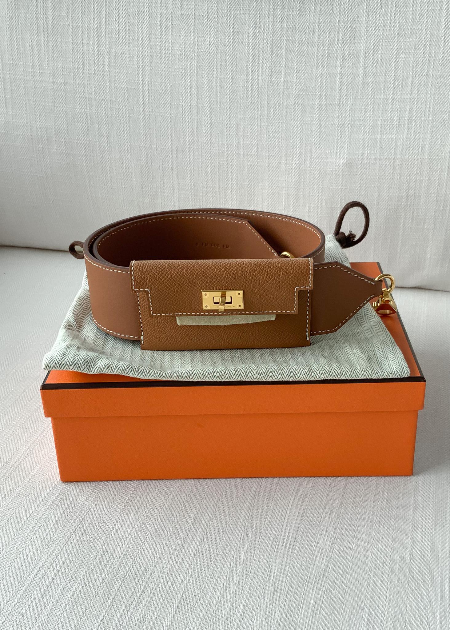 Shop this Hermès Kelly Pocket Bag Strap in the most classic colour way of Gold on Gold. The Kelly Pocket strap is the perfect accessory for your bag, combining a practical card older and strap together. It is made from Swift leather, with an epsom