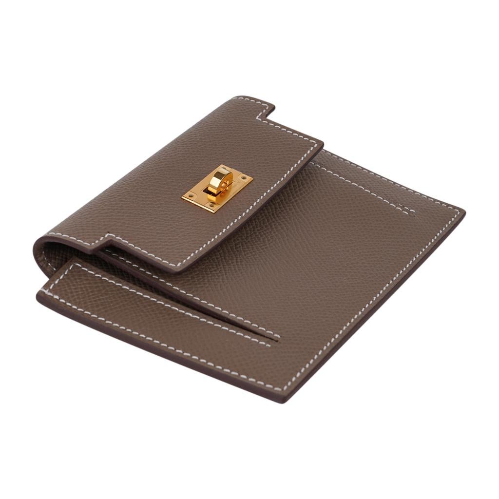 Guaranteed authentic Hermes Pocket Compact Wallet featured in Etoupe with signature bone topstitch.
Espom calfskin.
Striking with Gold Hardware, this compact wallet has a central pocket and rear
Kelly Cadena zipped change purse.
NEW or NEVER