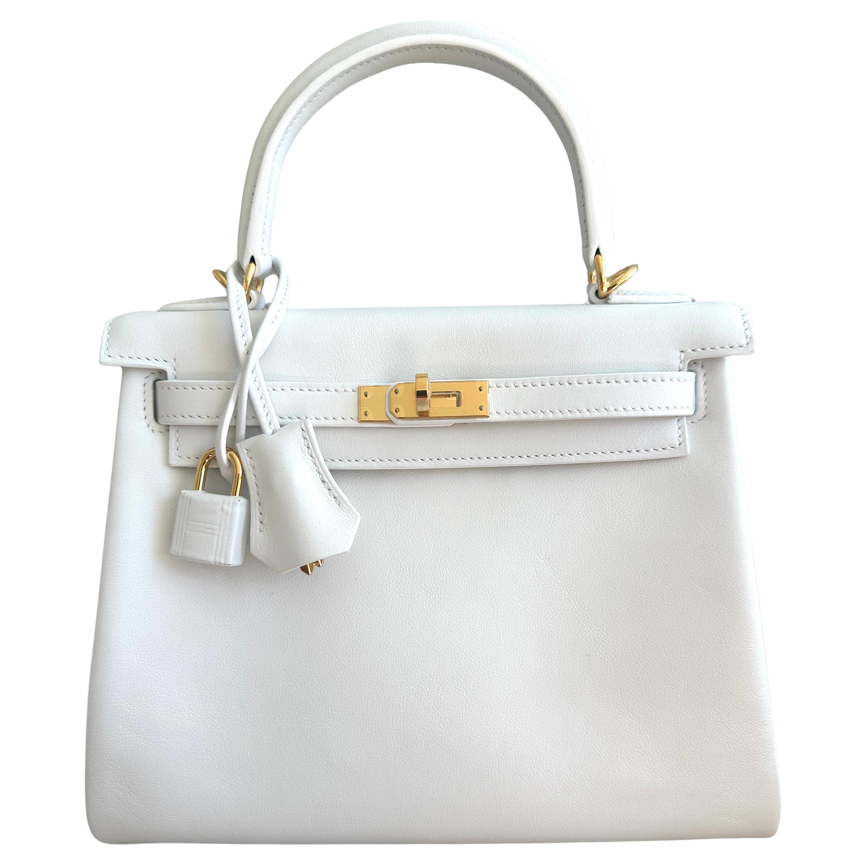 
Hermes Retourne Kelly 25cm
An Hermès Kelly 25, beautifully handcrafted from Swift leather in Bright White, called New White topped with Gold-plated hardware.

Very Rare to find white with gold in this combination leather.

This Kelly, in the