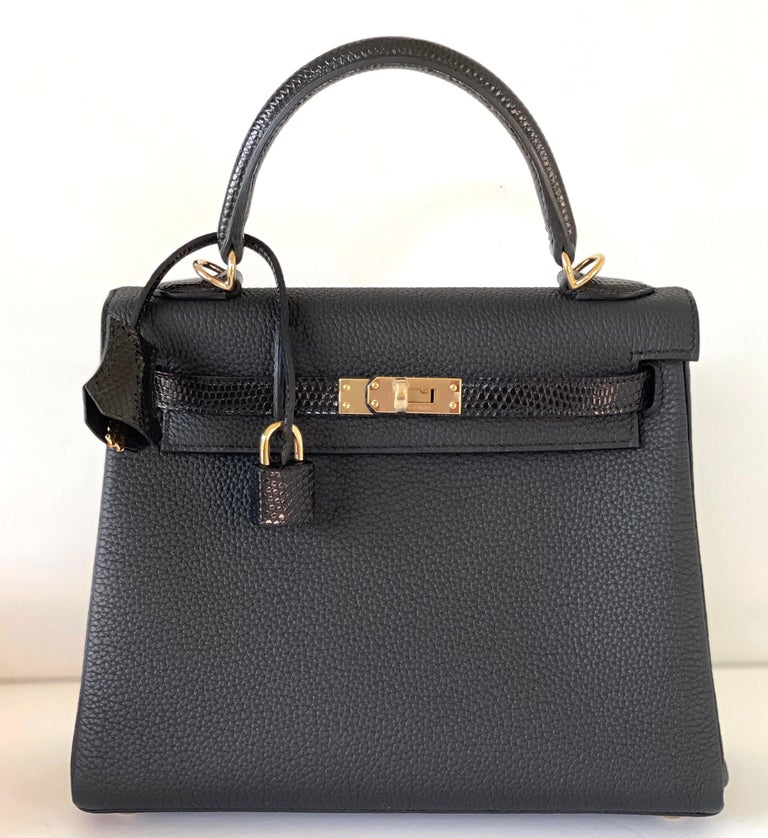 Hermes Kelly 25cm
This Kelly Touch, is in Black Lizard and Black Togo leather with light gold hardware and has tonal stitching, front flap, two straps with center toggle closure, clochette with lock and two keys, and double rolled handles.

This bag