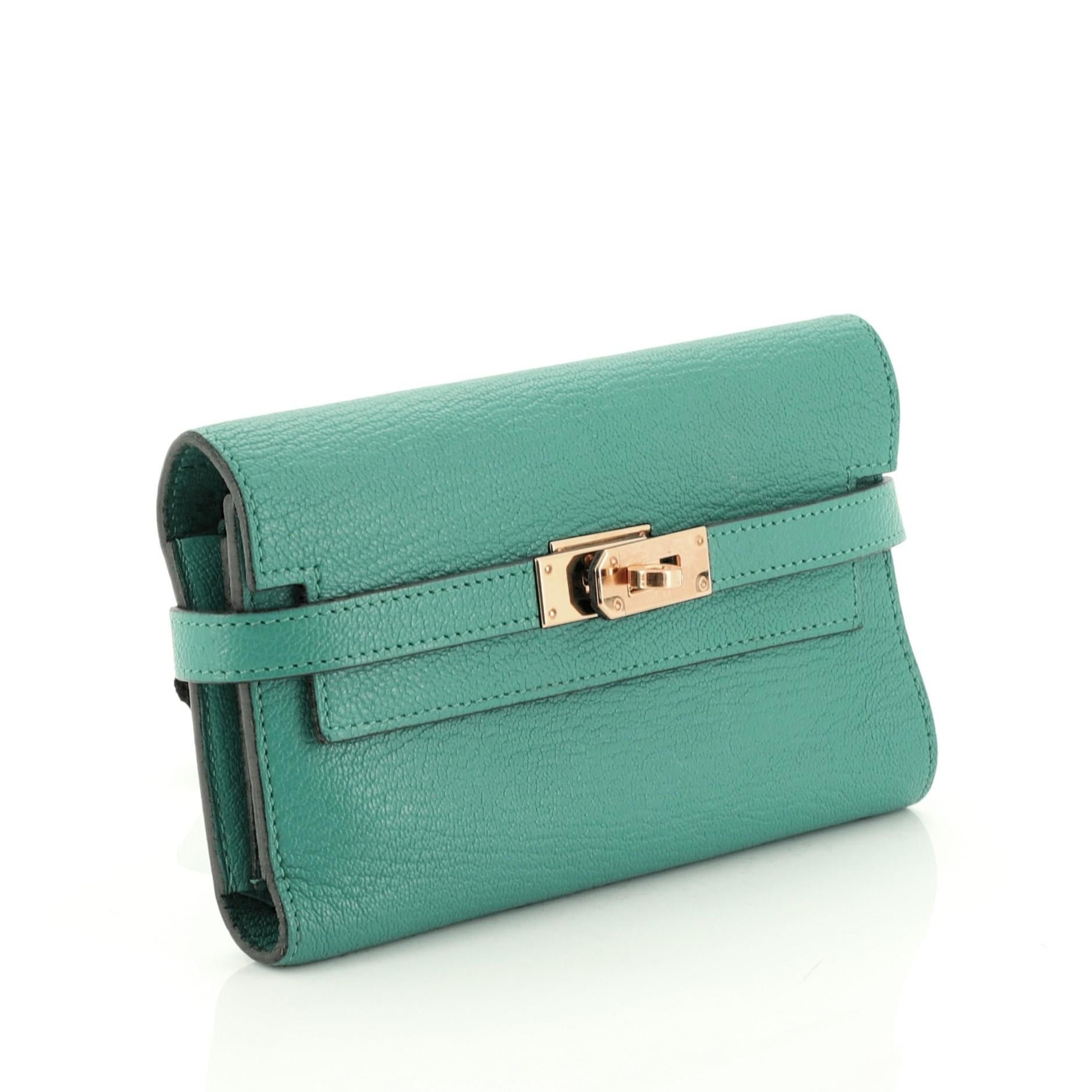 This Hermes Kelly Trifold Wallet Chevre Mysore Small, crafted in Vert Verone green Chevre Mysore leather, features gold hardware. Its turn-lock closure opens to a Vert Verone green Chevre Mysore leather interior with multiple card slots and zip