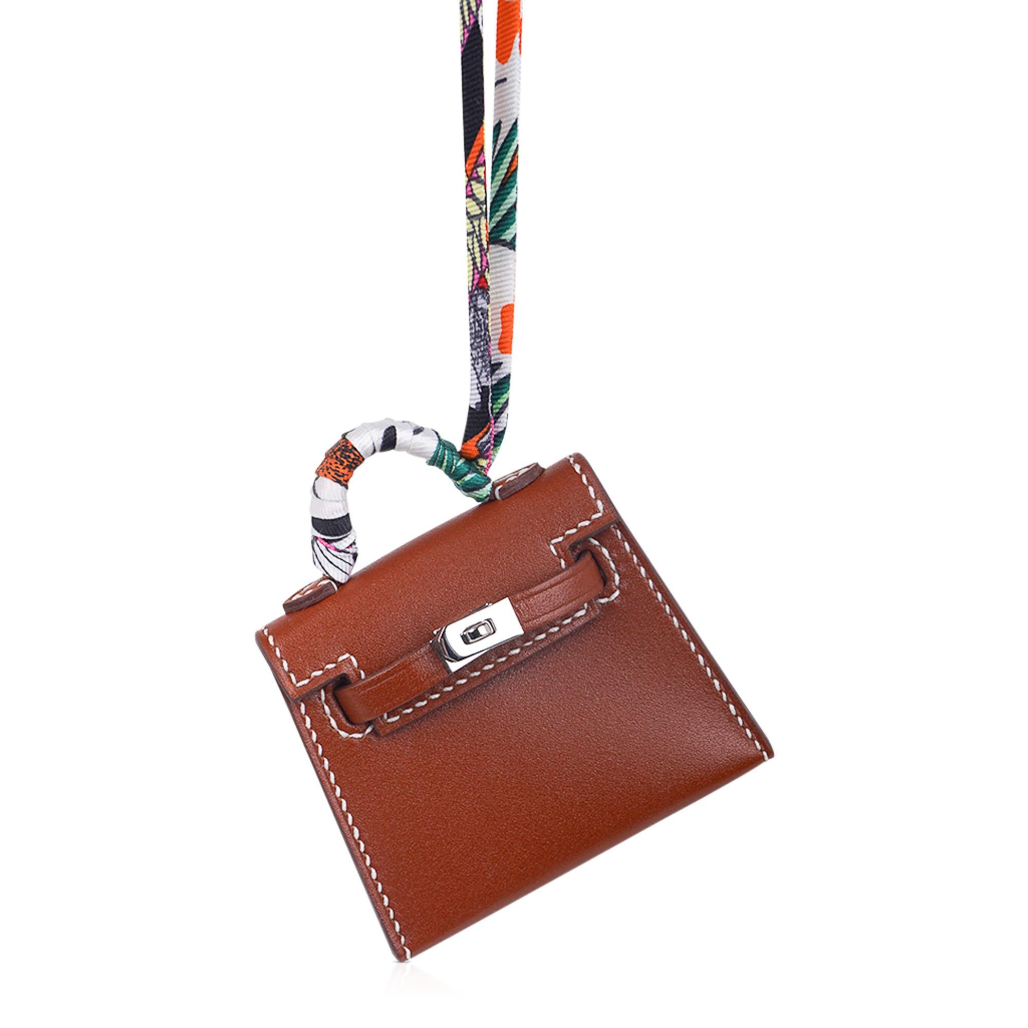 Mightychic offers a limited edition Hermes Kelly Twilly Bag Charm featured in Fauve with signature bone topstitch.
Shaped like a Kelly Bag crafted in Tadelakt leather with amazing detail with working hardware.
The charm has Palladium hardware and a