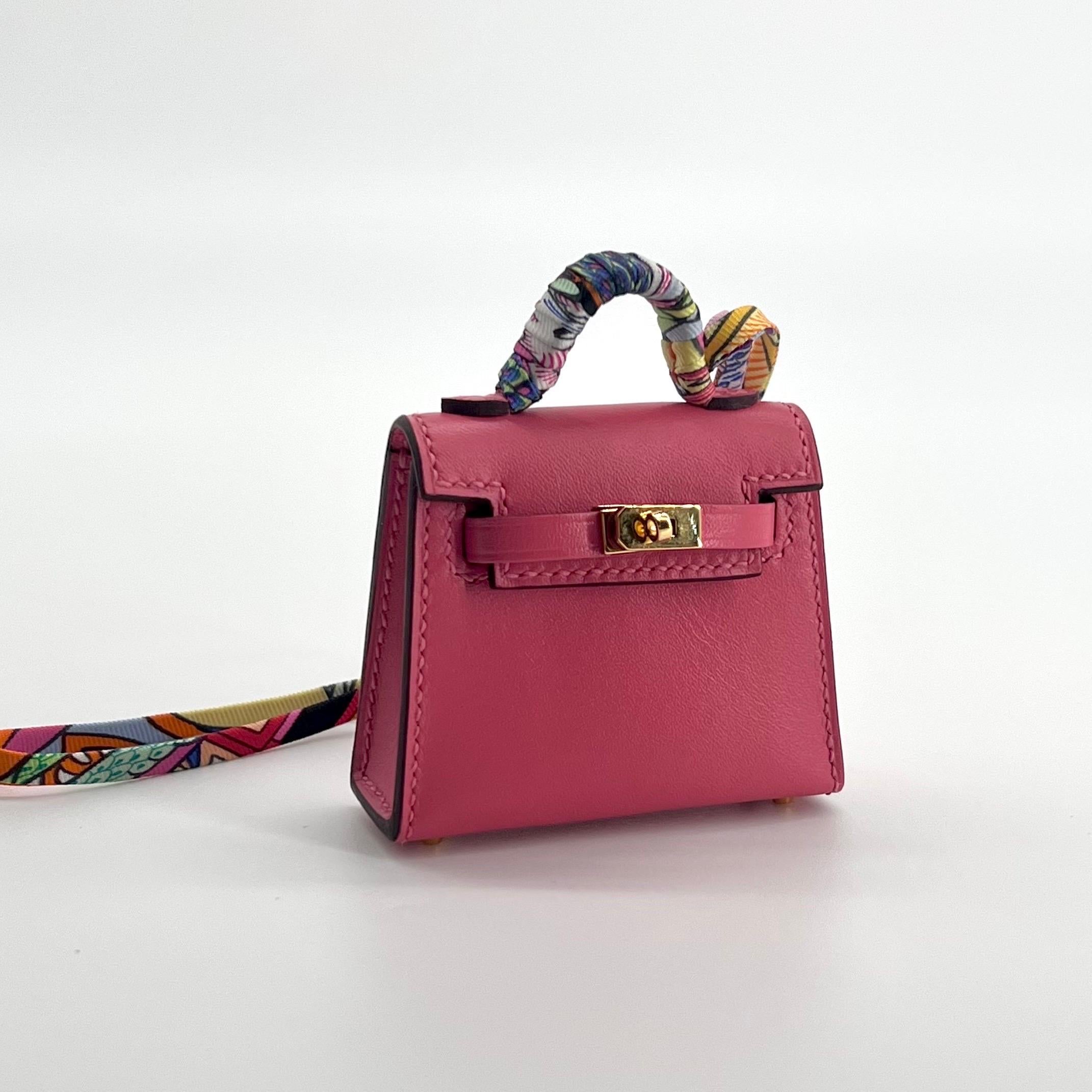 This Micro Kelly Twilly bag charm from Hermès is the smallest Kelly bag. This Hermès Kelly Twilly Charm is made from Veau Tadelakt leather with a Gold Hardware. Similar to swift leather. The beautiful charm is in the colour of Lipstick Pink with a