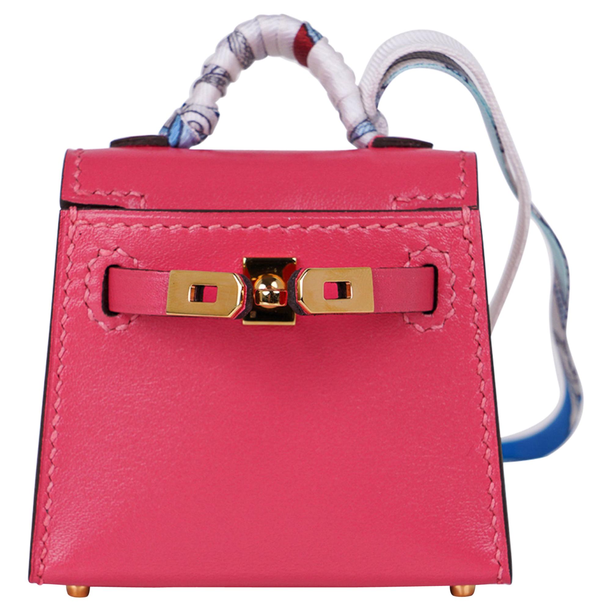 Mightychic offers a very rare limited edition Hermes Kelly Twilly Bag Charm features a miniature Kelly in Rose Lipstick.
Shaped like a Kelly Bag crafted in amazing detail.
The charm has Gold Hardware and a wrapped handle in a silk print
