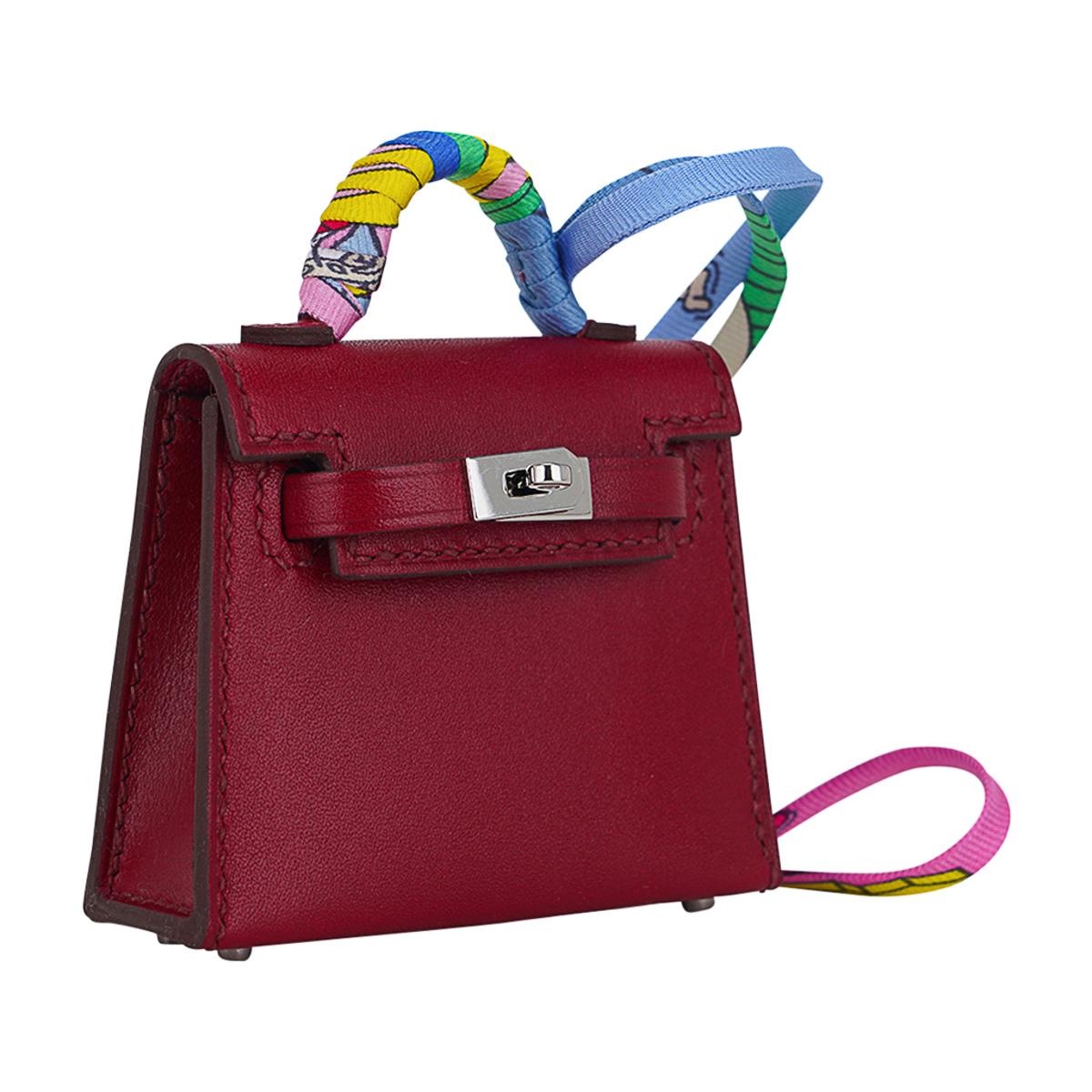Mightychic offers a limited edition Hermes Kelly Twilly Bag Charm featured in gorgeous Rubis.
Shaped like a Kelly Bag crafted in Tadelakt leather with amazing detail with working hardware.
The charm has Palladium hardware and a wrapped handle in a