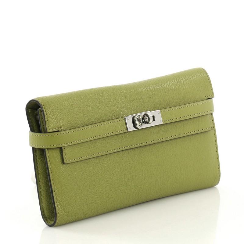 This Hermes Kelly Wallet Chevre Mysore Long, crafted in Vert Chartreuse green Chevre Mysore leather, features palladium hardware. Its turn-lock closure opens to a Vert Chartreuse green Chevre leather interior with middle zip compartment, slip pocket