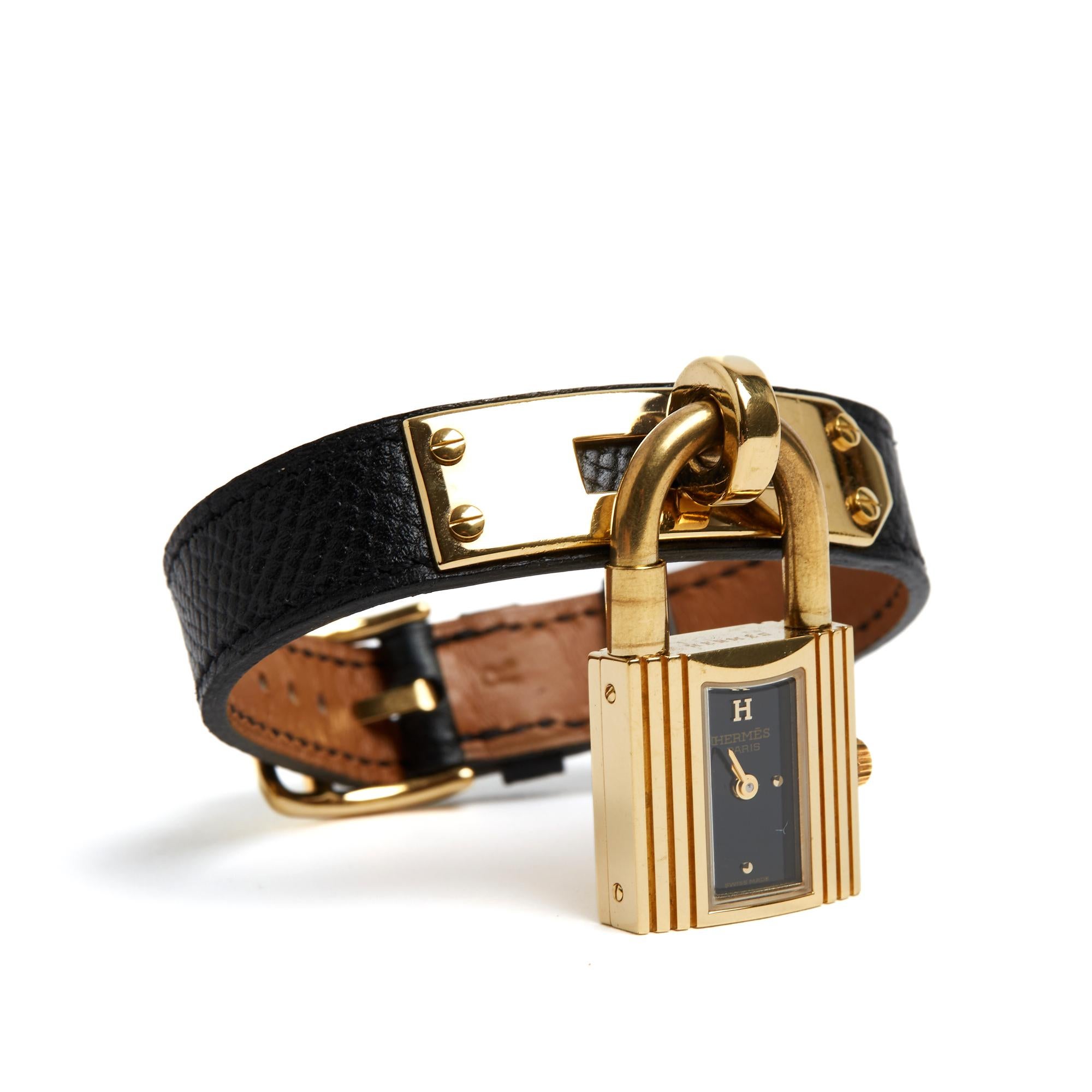 Orologio Hermès modello Kelly in metallo placcato oro, quadrante nero con indici a forma di collare di cane in metallo placcato oro a ore 12, 3, 6 e 9, movimento al quarzo (batteria), cinturino in pelle nera finemente granulata, fibbia ad ardiglione