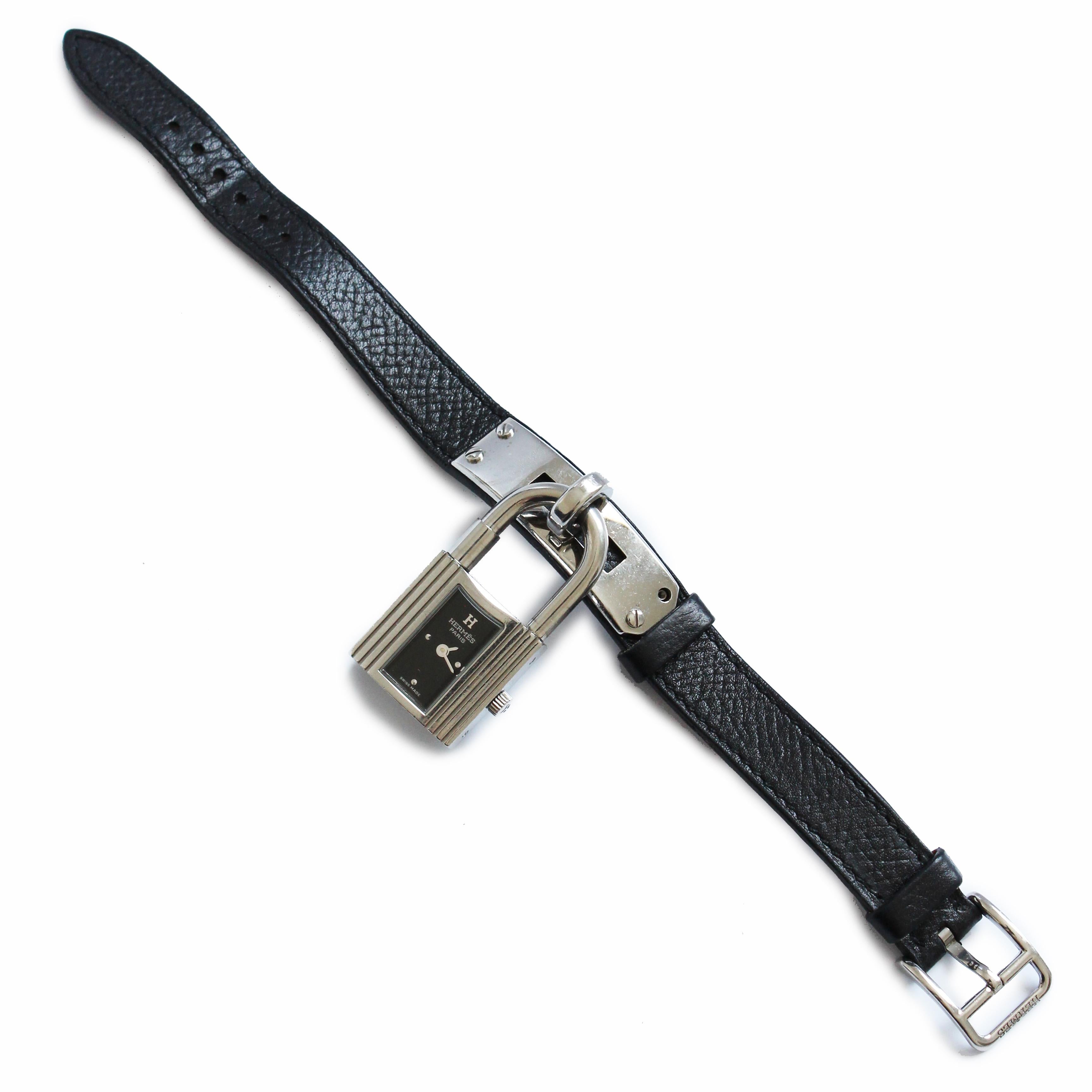 Authentic, preowned, vintage Kelly Cadena Lock Charm Watch in silver metal with black Epsom Calfskin leather, made in 2004.  The strap is stamped H in a square (2004 production); the watch has a black face with silver 1/4 hour markers. The Cadena