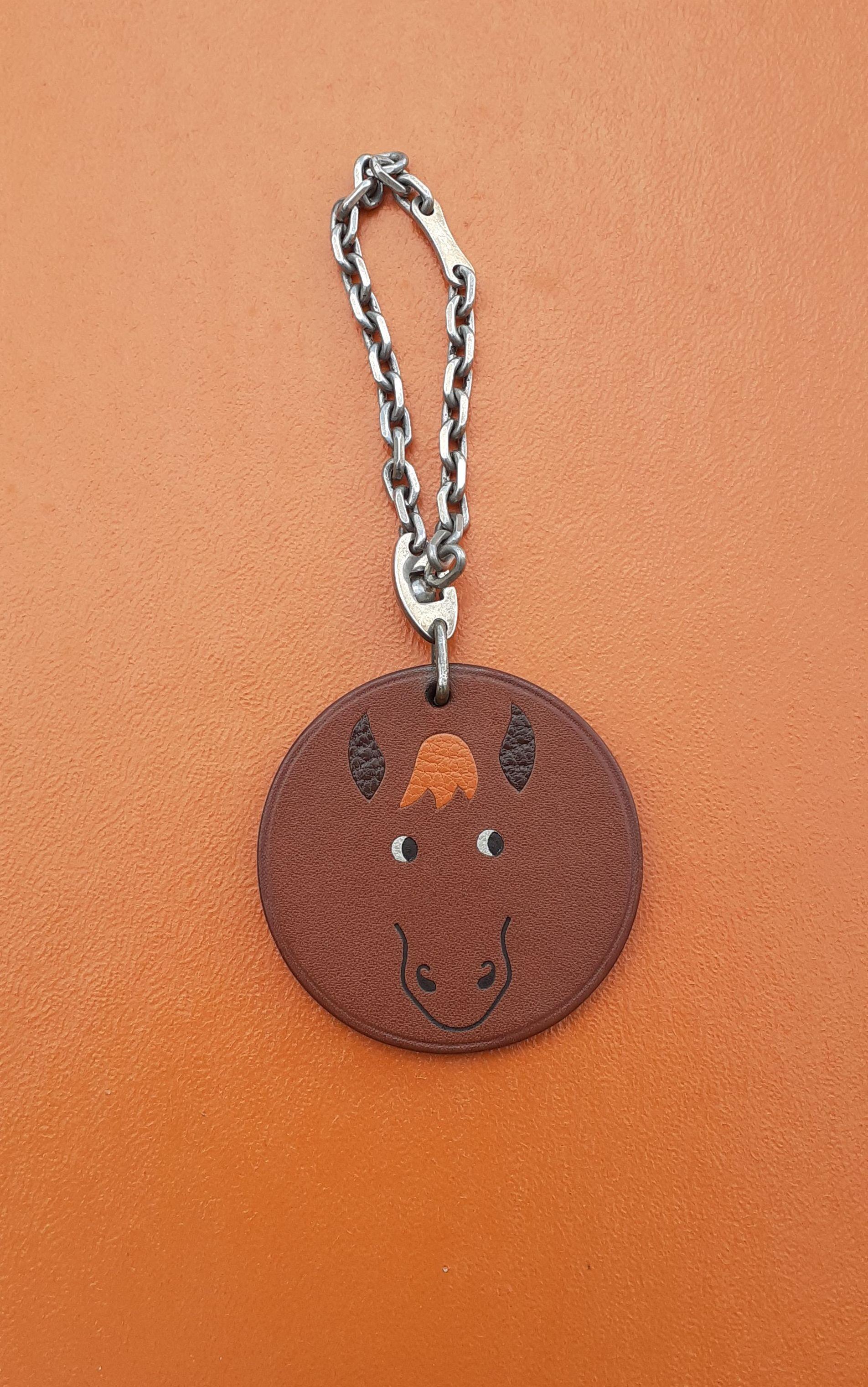 Super Cute Authentic Hermès Key Holder

Can be used as charm for your Kelly, Birkin or any other Hermès bag

Round in shape, printed with a cute horse's head

Made of barenia smooth leather and sterling silver chain / Ears and mane made of grained