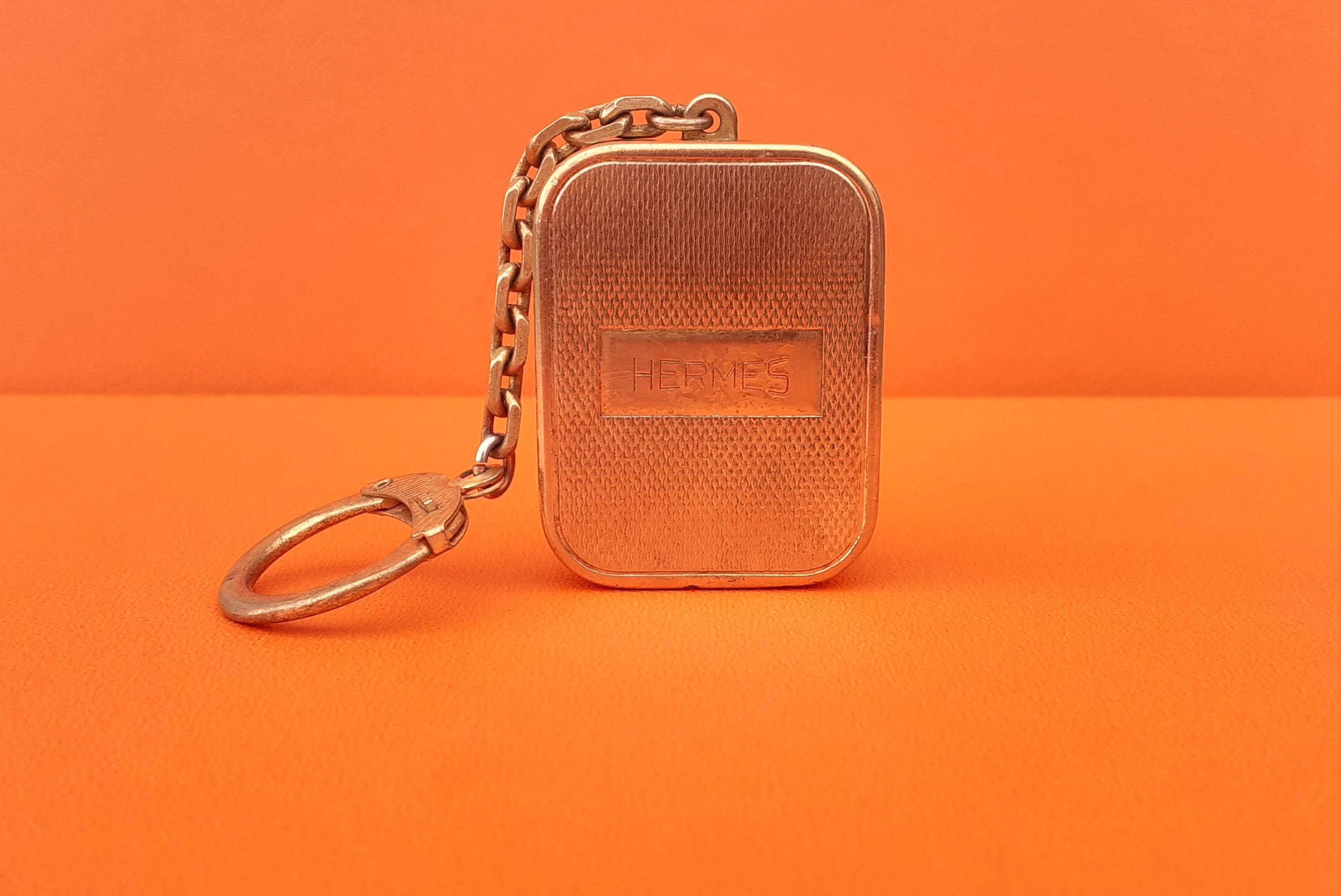 Rare Authentic Hermès Keychain

It is also a music box ! Please ask for a video if you want to hear the music

Turn the mechanical key (at the back) clockwise and pull up the small button to hear the music 

Made by Reuge Sainte Croix, specialist