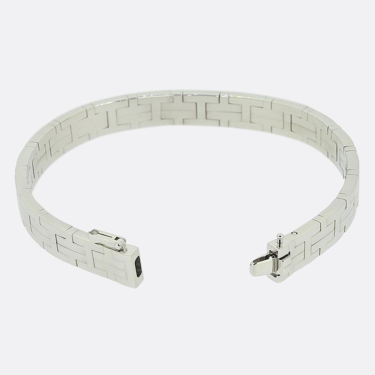 Here we have an elegant 18ct white gold bangle from the world renowned luxury designer, Hermès. This piece forms part of their 'Kilim' collection and is composed of interlocking embedded 