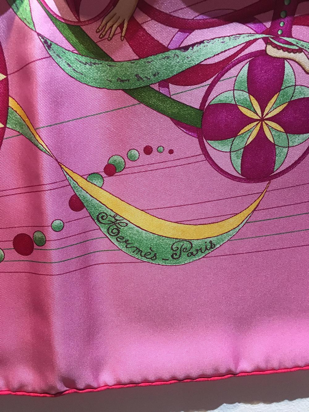 Hermes La Danse du Cosmos Silk Scarf in Pink in excellent condition. Original silk screen design c2007 by Zoé Pauwels features 3 dancers with a beautiful multicolor green, pink, red, yellow, and magenta ribbon, dot, and geometrical cylindrical print