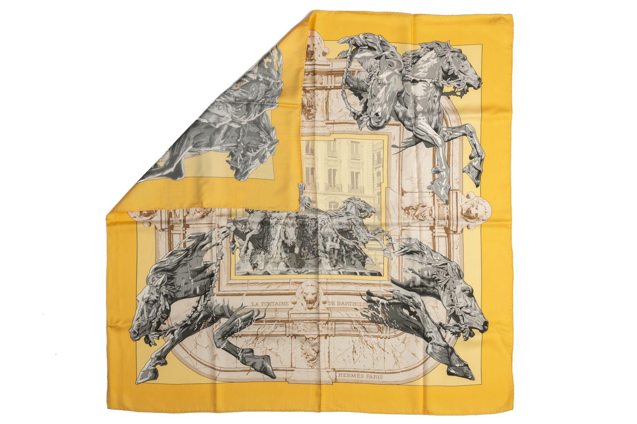 Hermès La Fontaine de Bartholdi gold silk scarf with silver and grey details. Hand-rolled edges. Original box included.