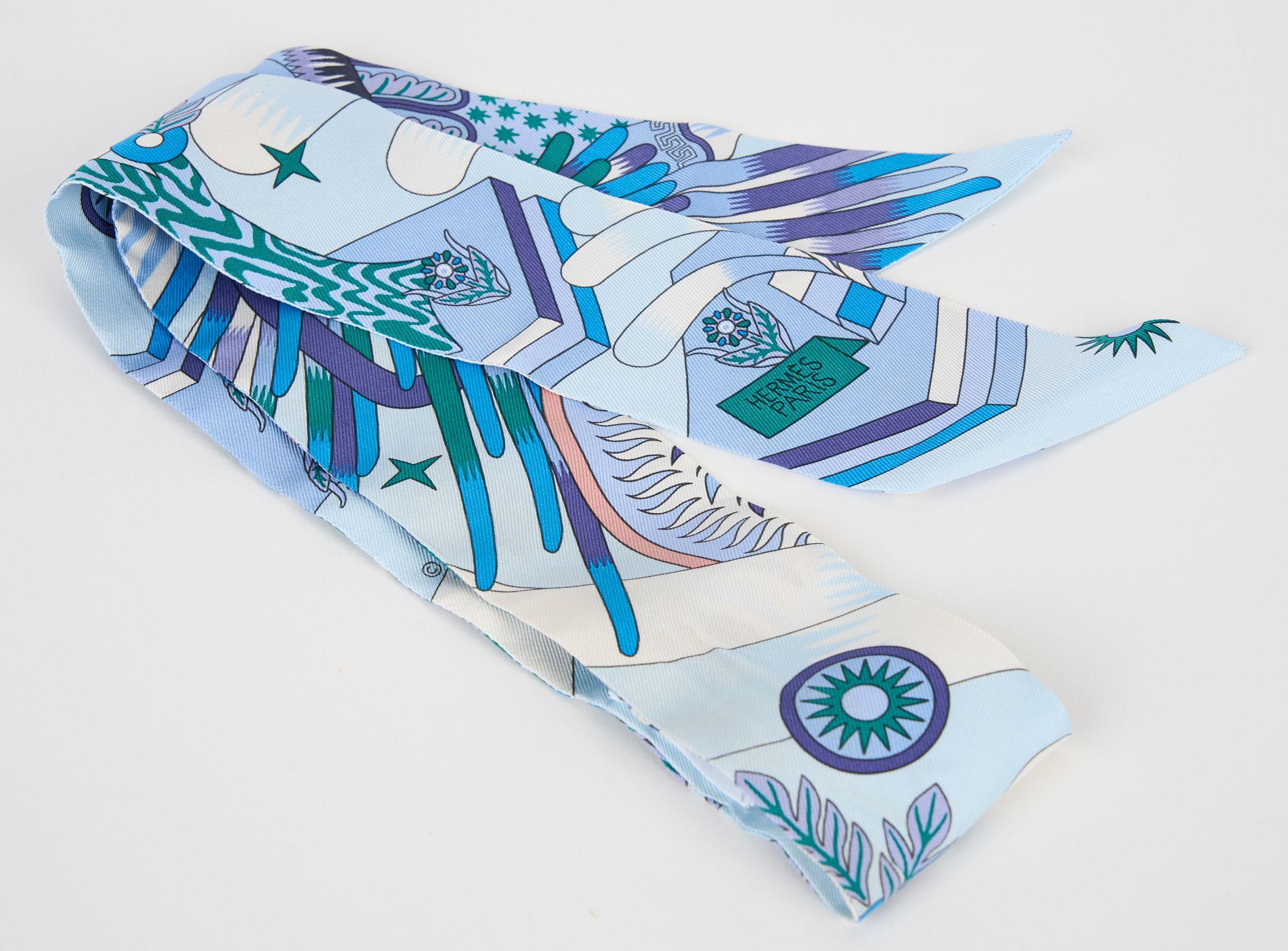 Questo Twilly di Hermès La Source de Pegase è realizzato in seta al 100% e presenta un pegaso alato danzante nei colori del blu. Può essere indossata in diversi modi con una medaglia a scorrimento in metallo dorato. Viene fornito con la scatola