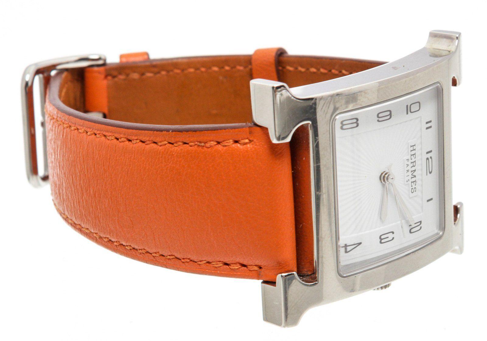 Stainless steel 30.5mm x 30.5mm Hermès Heure H watch featuring a quartz movement, smooth bezel, silver dial and orange leather strap with tang buckle.

14989MSC