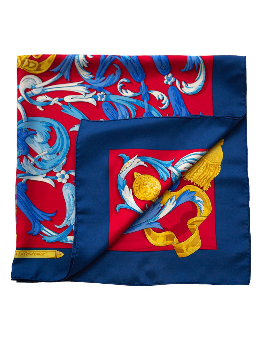 Crafted in France from the finest navy and red silk, this pre-owned scarf by Hermès features lightweight construction, a square shape and print motifs. Designed by Henri d'Origny for Hermes in 1970, this scarf depicts an equestrian theme, a