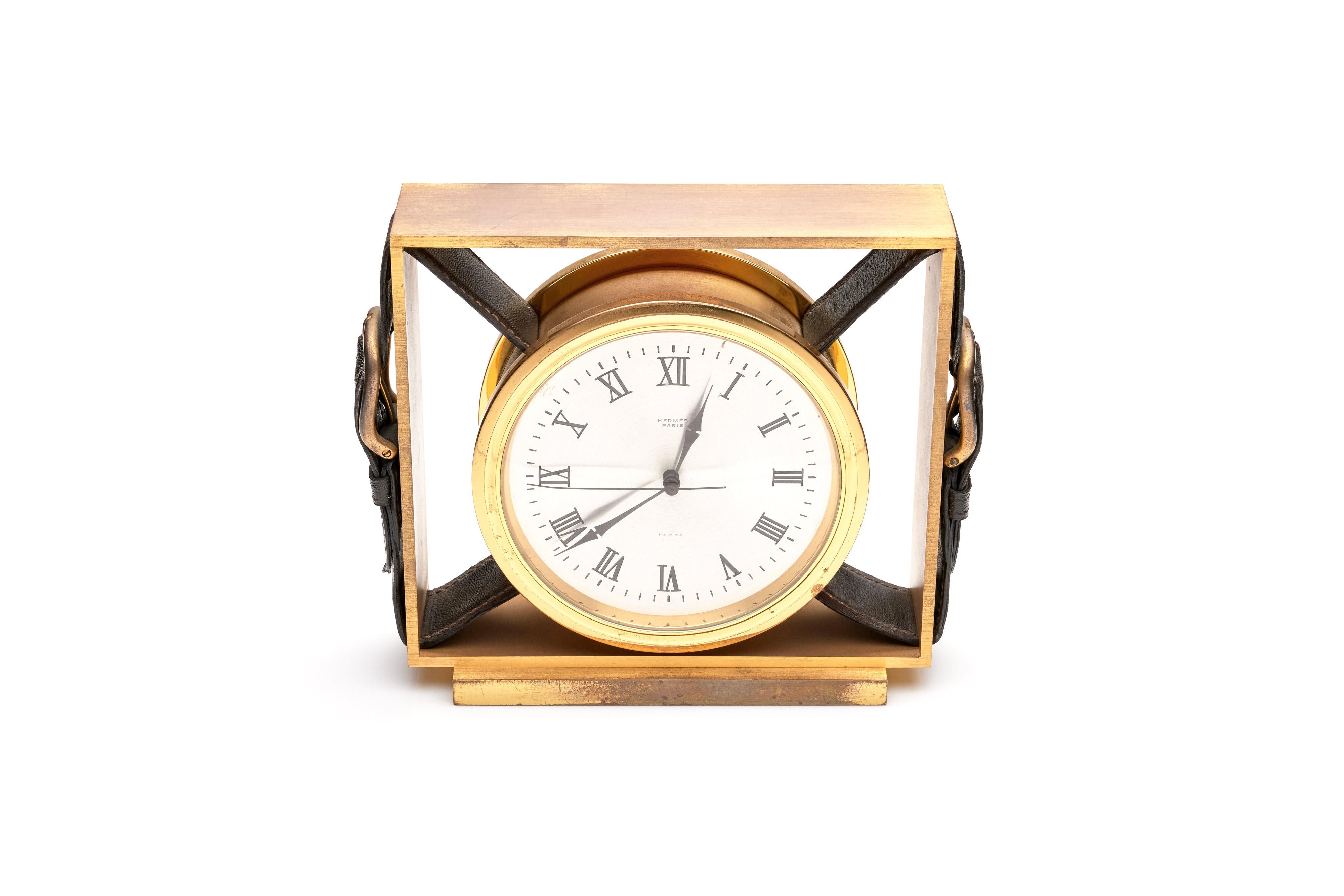 A fine Hermes clock with a gold-plated brass case with leather belt buckles. Roman numeral dial, quartz movement. 

1970s

Marked on dial.

Measures: 6.25