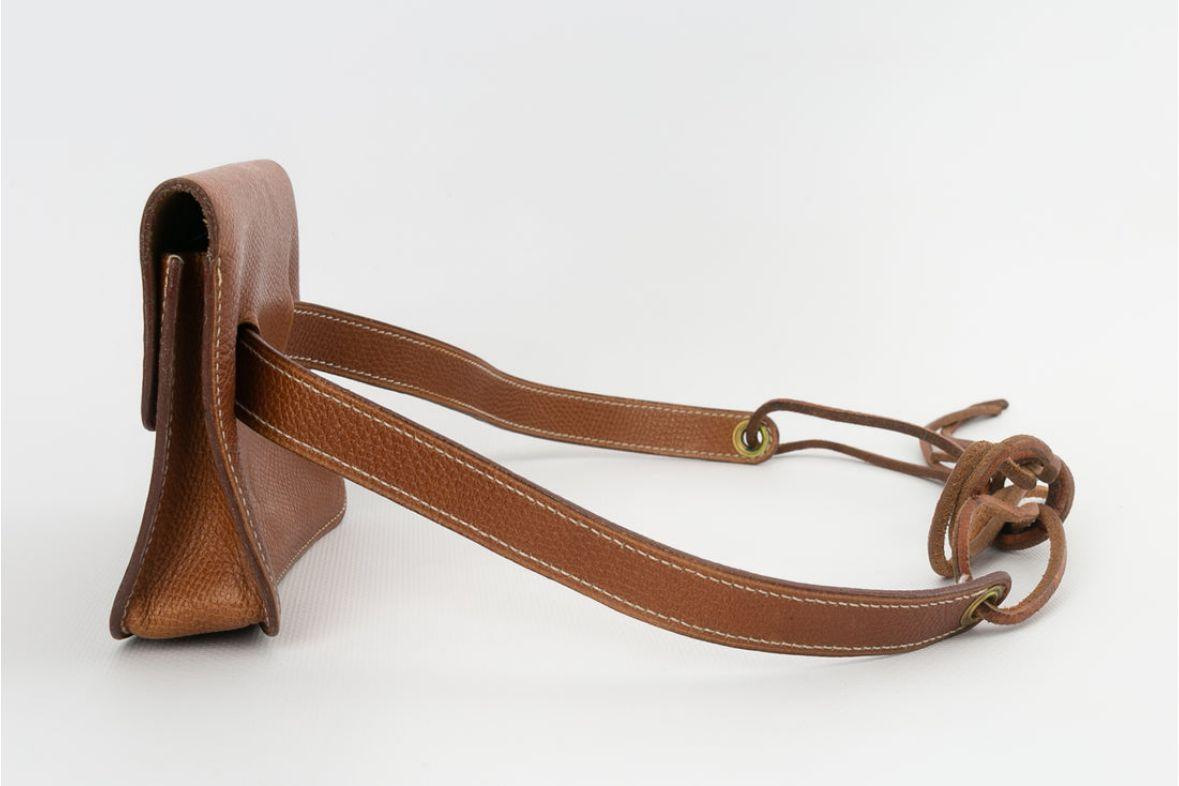Hermes (Made in France) Petite pochette-ceinture en cuir marron. La ceinture peut être ajustée à l'aide de Cordes sur lesquelles la pochette coulisse.
Collection prêt-à-porter printemps/été 1998.

Informations complémentaires : 
Dimensions :