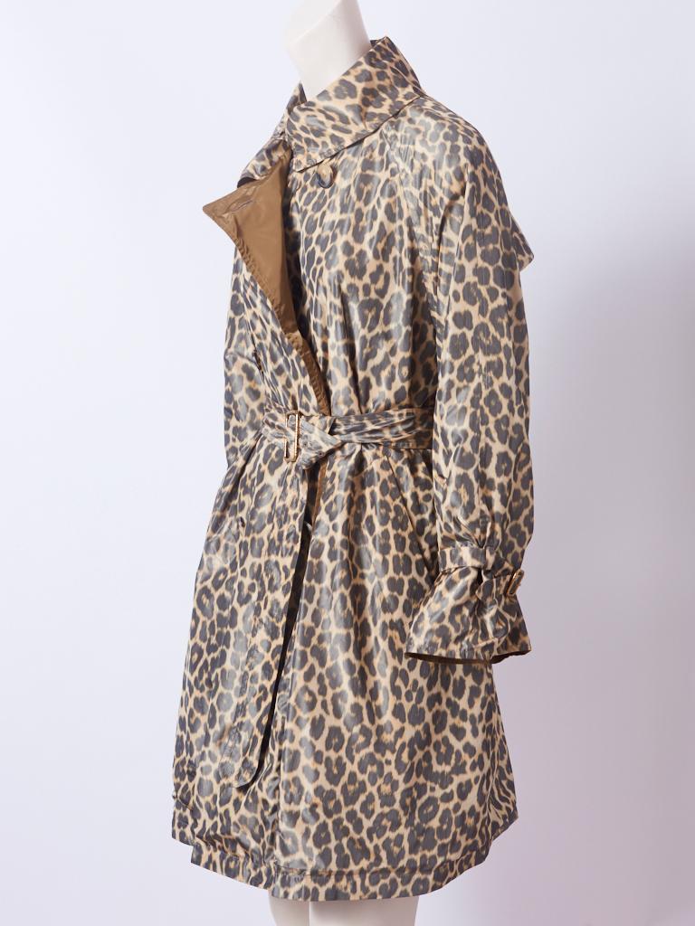 Hermès, classic, belted, reversible trench, having a swing style silhouette ( when not belted) and a leopard pattern on one side and a camel, solid tone on the other side. Hidden side pockets. Label is found inside the pocket so that the trench can