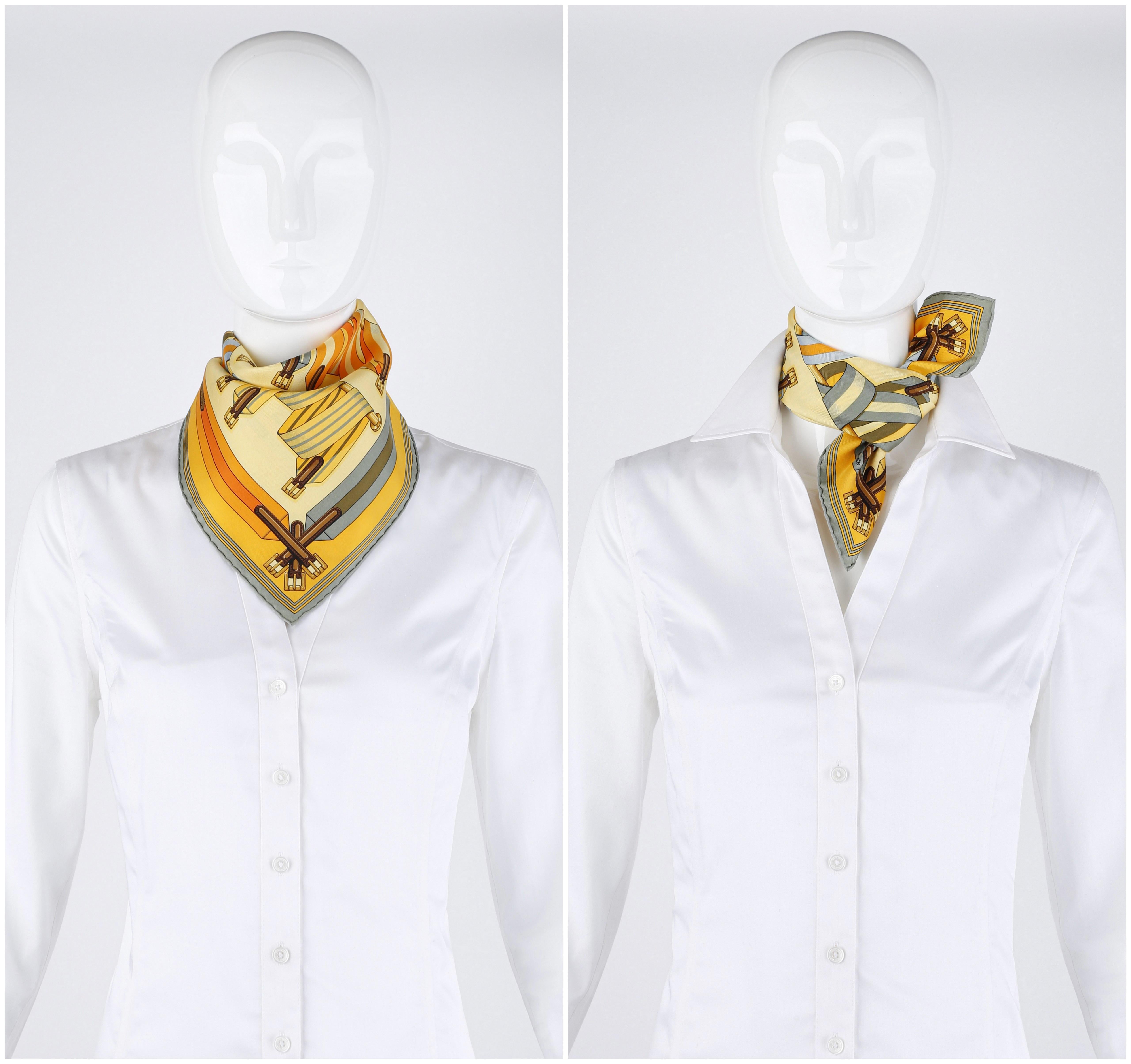 Author: J. Metz. Square shaped scarf / pocket square. Pattern features an assortment of striped buckled straps beautifully looped around 3 gold bars. This striking pattern is framed by more geometric striped straps and buckles. Hand rolled edges.