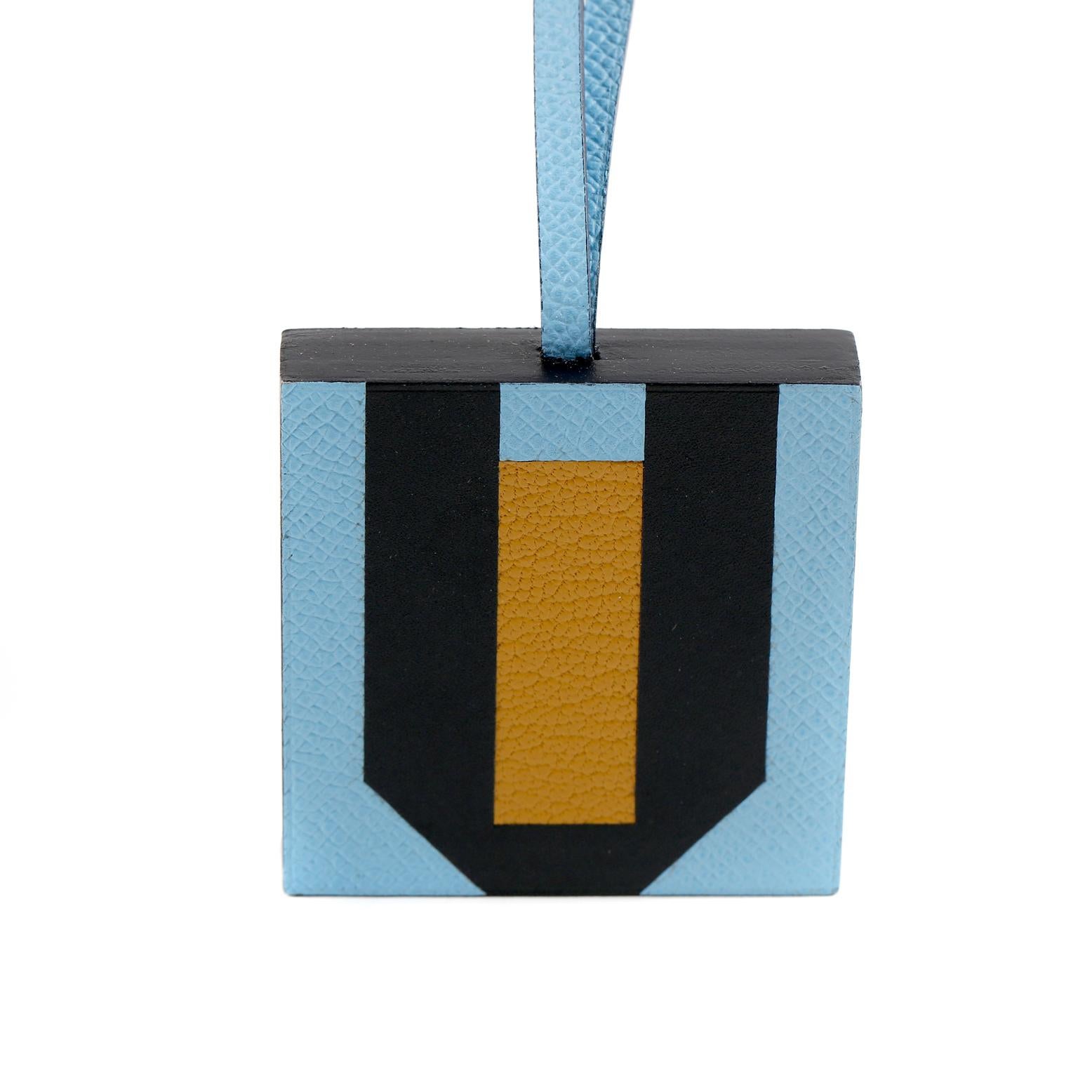 This authentic Hermès Lettre au Carre U Bag Charm is in pristine condition.  Epsom leather and goatskin.  Celeste, Ambre, and Bleu Obscur.  Approximately 2.4” x 2.4” x 0.6”


