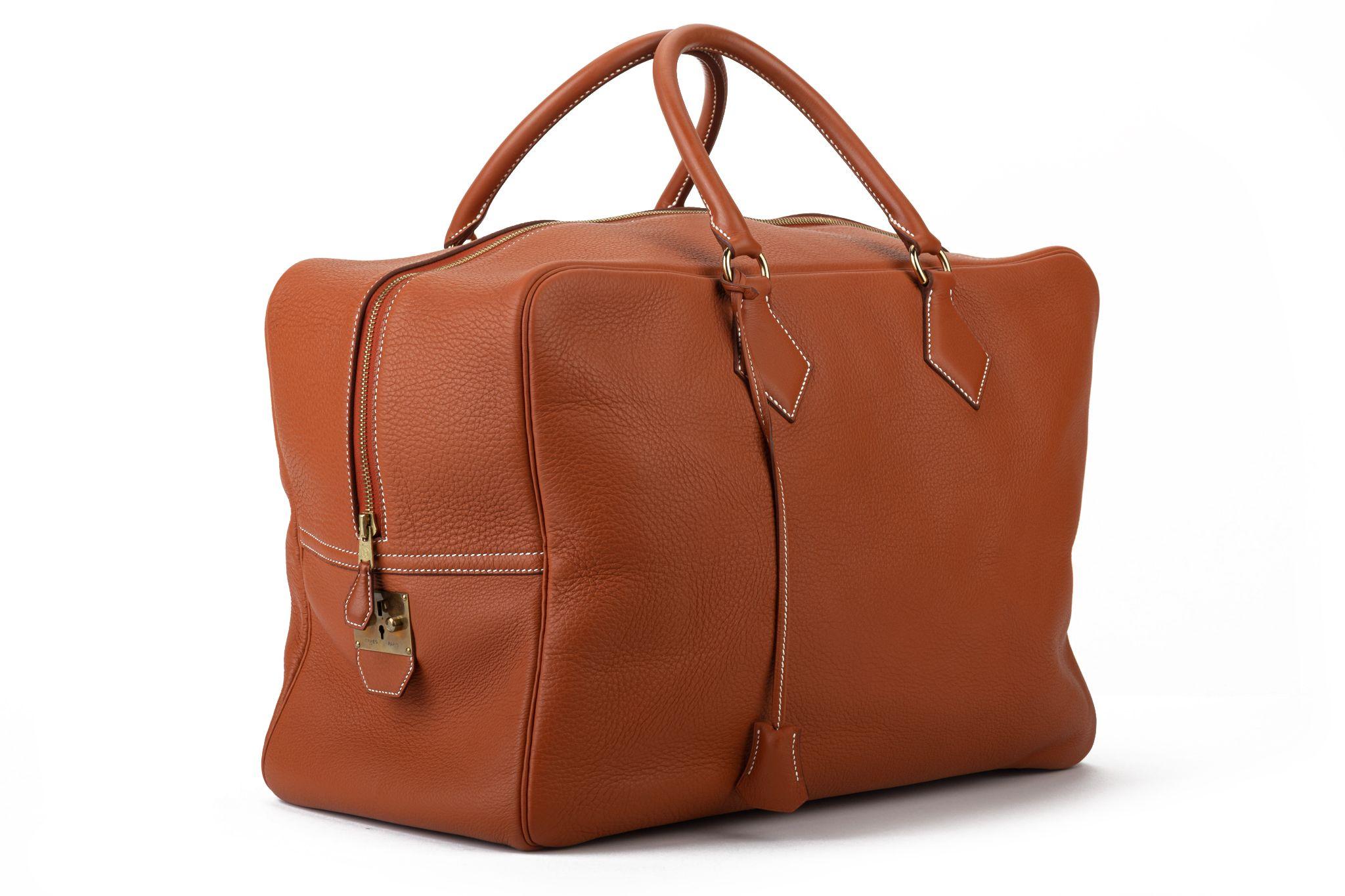 Hermès Victoria weekender bag in rust leather and gold tone hardware. Handle drop 5”. Date stamp A for 1997. Comes with key and generic dust cover .