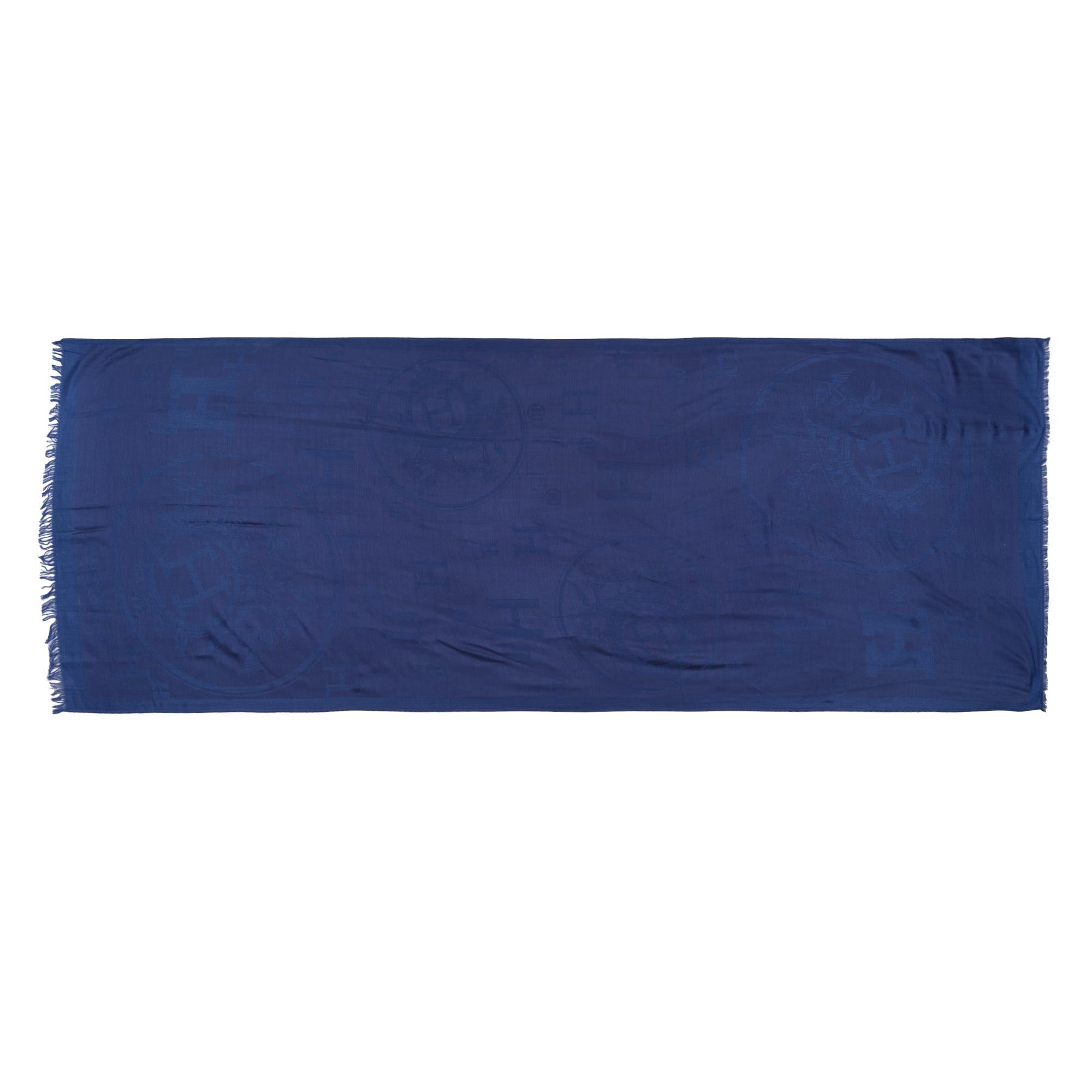 This​ ​Hermès​ ​New​ ​Libris​ ​stole​ ​is​ ​of​ ​Bleu​ ​De​ ​Chine​ ​cashmere​ ​and​ ​silk​ ​fabric,​ ​featuring​ ​a​ ​jacquard​ ​weave​ ​with​ ​the​ ​iconic​ ​Confettis​ ​d’Ex-Libris​ ​emblem​ ​and​ ​designed​ ​by​ ​Sandy​ ​Queudrus.​ ​Soft​ ​and​