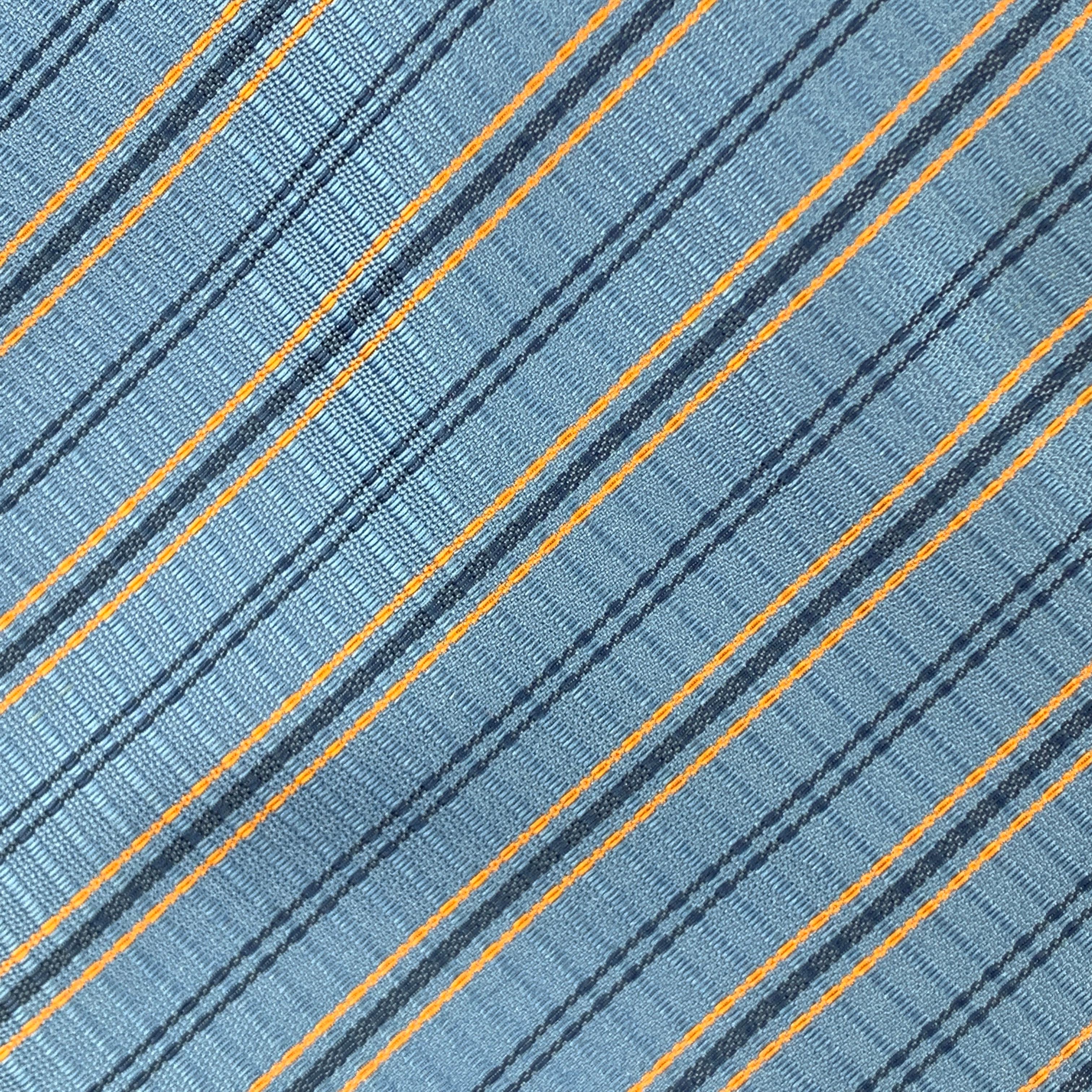 HERMES necktie comes in light blue silk twill with all over Orange stripe plaid print. Made in France.

Excellent Pre-Owned Condition.

Width: 3.75 in. 