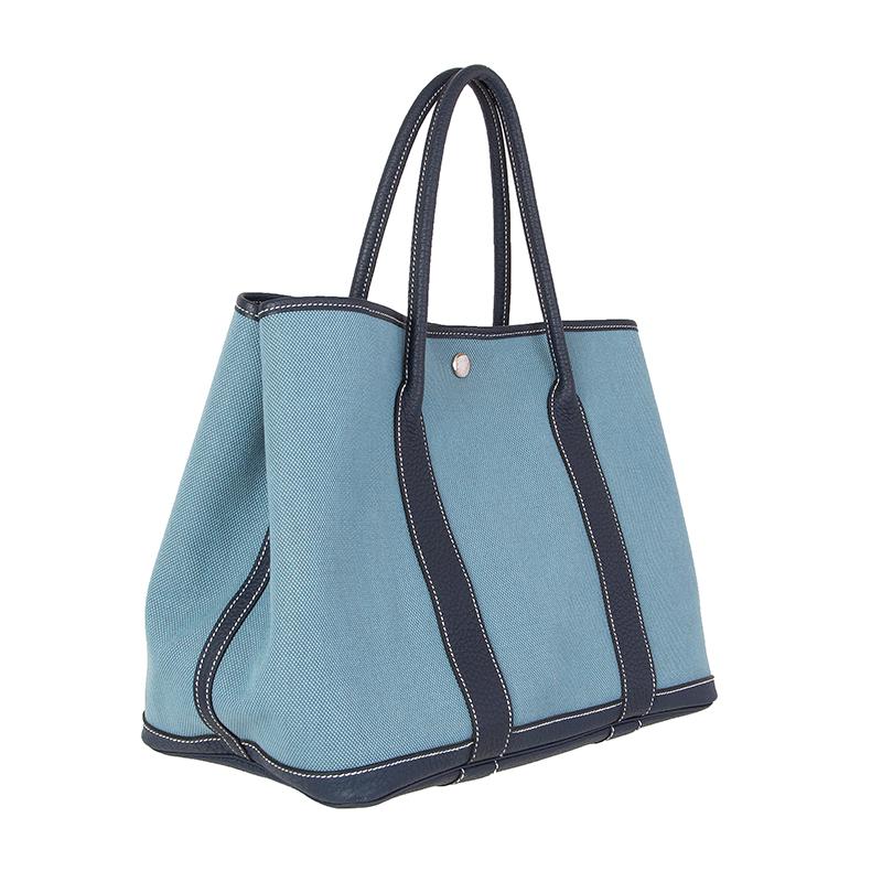 100% authentic Hermes 'Garden Party 36' tote in light blue Toile H canvas with leather trims in Bleu de Prusse Veau Negonda leather and contrasting white stitching. Unlined. Closes with a snap-button on top. Has been carried and is in excellent