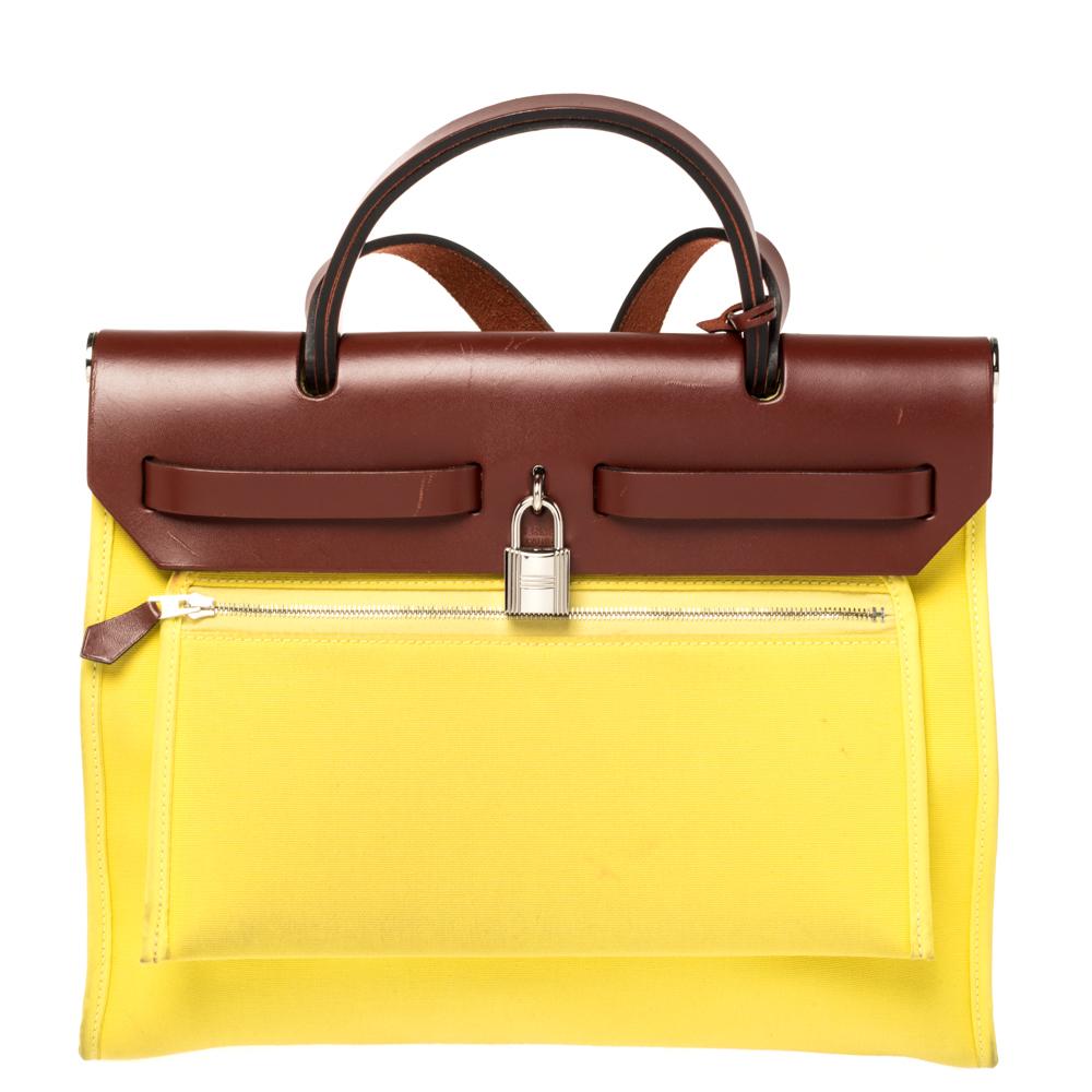 Made from yellow canvas and leather, the Herbag Zip is just as outstanding as all of Hermes' other handbags. First introduced in 2009 as a new version of the Herbag, this piece comes with a single handle, a long shoulder strap and it flaunts