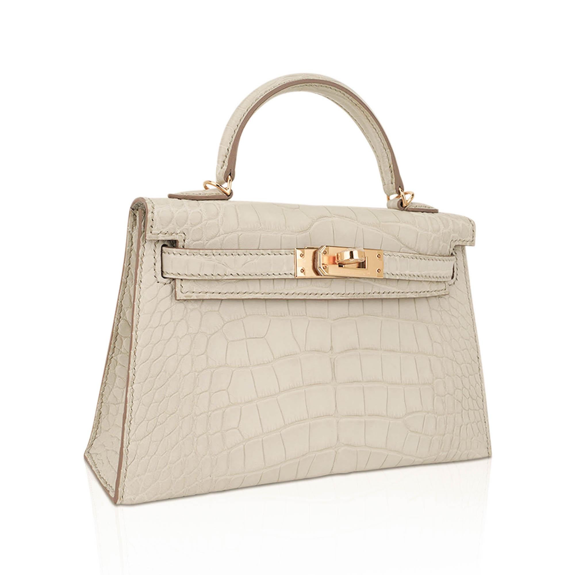 Mightychic offers a Limited Edition Hermes Kelly 20 Sellier bag featured in Beton Matte Alligator.
This mini Kelly bag is light gray with bone undertone (beton + concrete), and the neutral hue transitions seamlessly from day to evening, and from