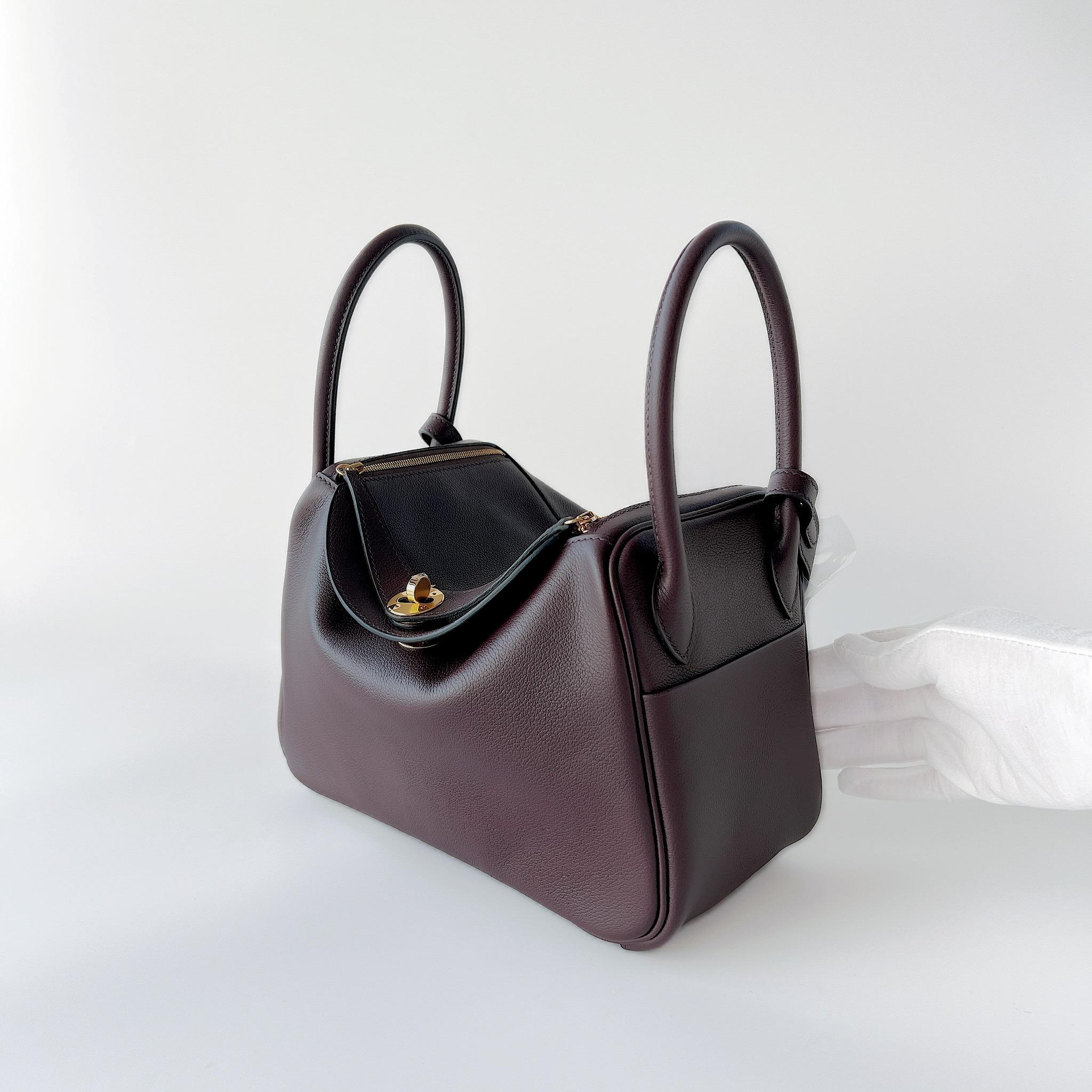 Shop this classic coloured Hermes Lindy 26 In Rouge Sellier Clemence Leather. It features Gold Hardware which gives the bag a more younger and stylish look. The Lindy 26 is a fantastic size bag for everyday use and fits much more than the Mini
