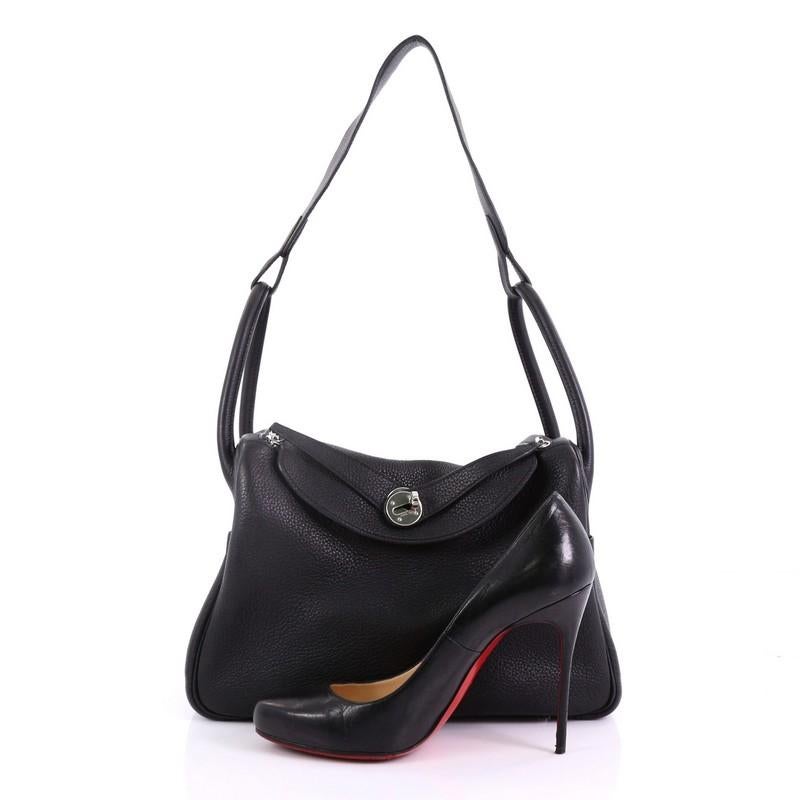 This Hermes Lindy Handbag Clemence 30, crafted from Noir black leather, features dual rolled handles, two side slip pockets, and palladium-tone hardware. Its turn-lock and dual zipper closure open to a black leather interior. Date stamp reads: L