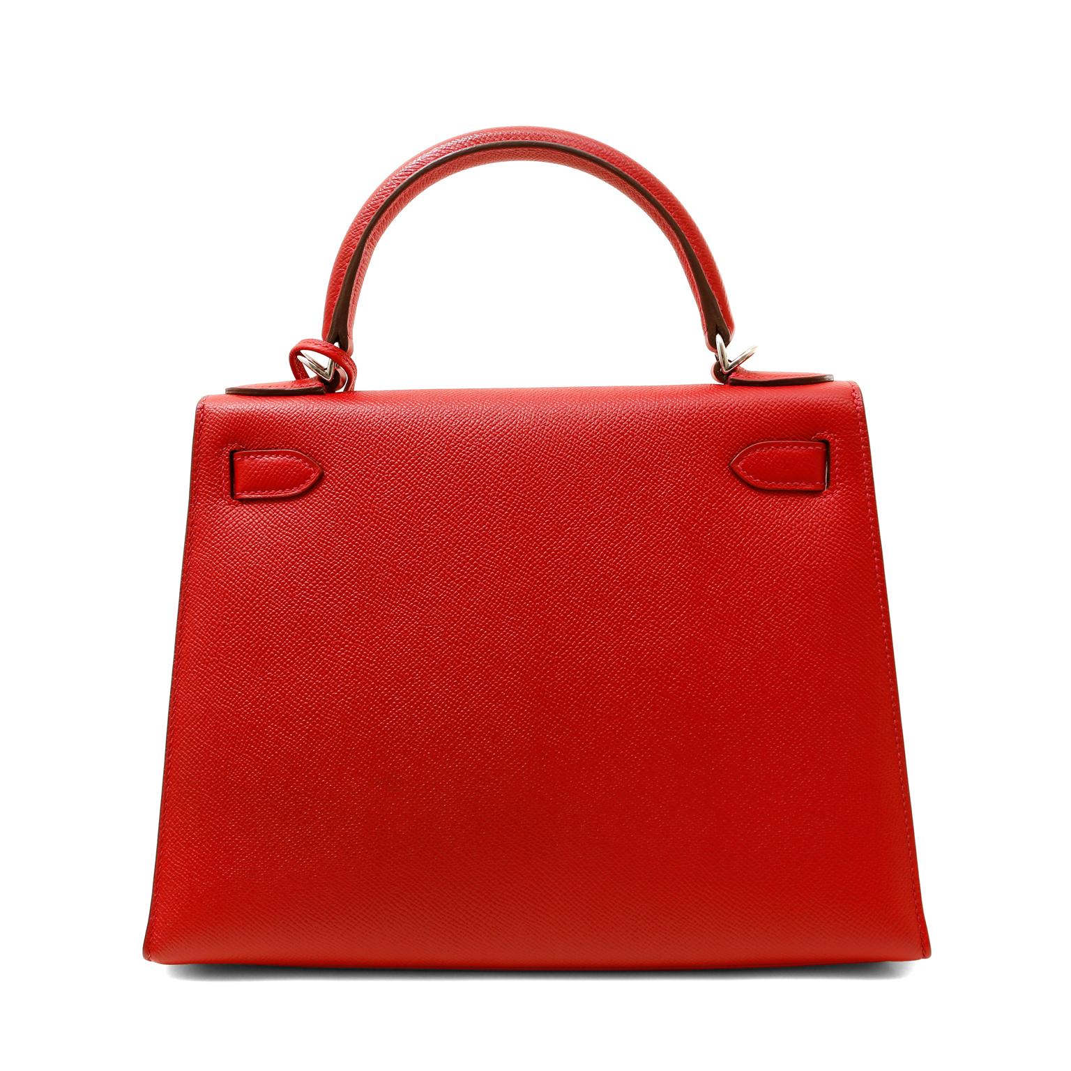 This authentic Hermès Lipstick Red Epsom 28 cm Kelly is in pristine unworn condition with the protective plastic intact on the hardware. The streamlined demure Kelly is always in high demand, but the 28 cm silhouette is possibly the most